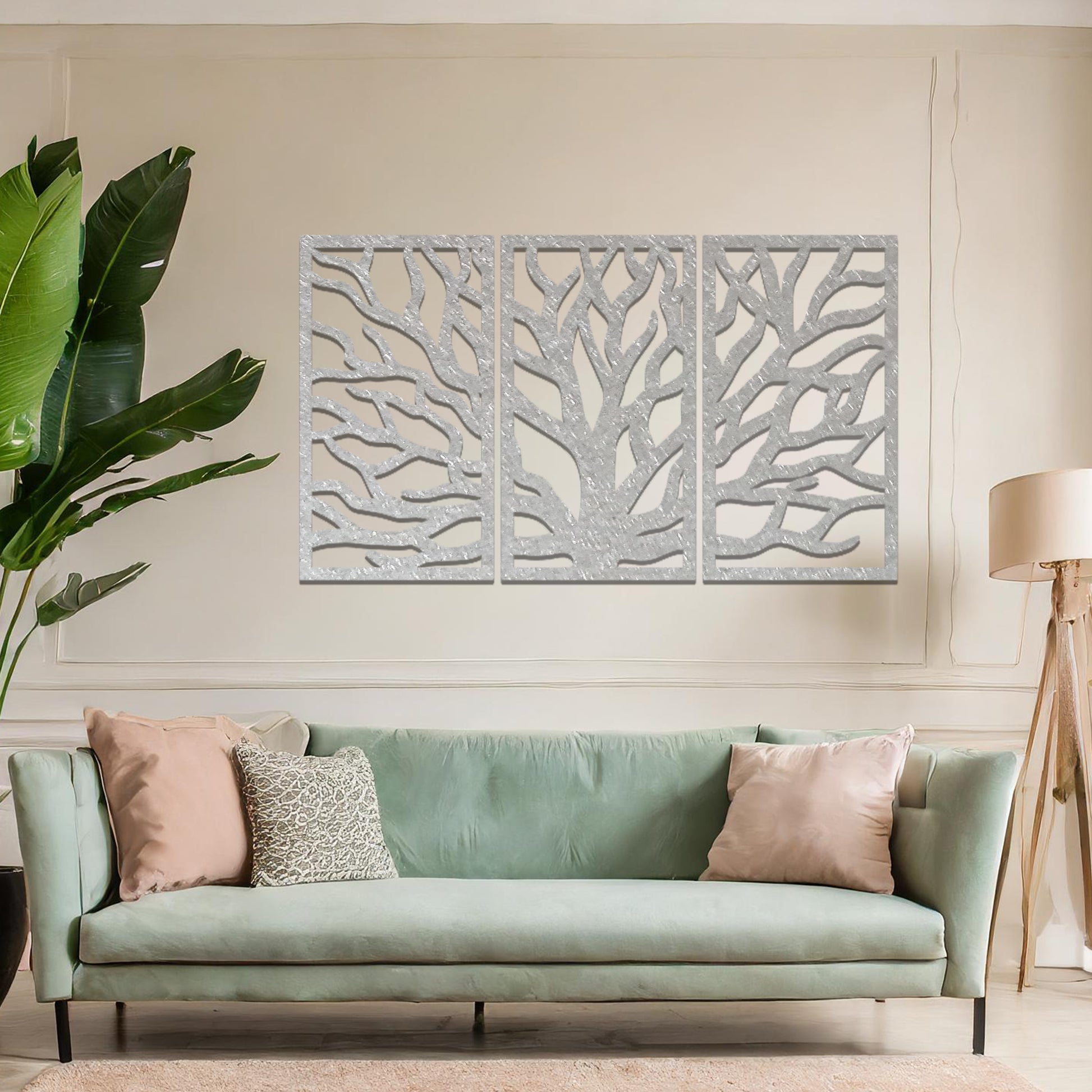 Metal wall art featuring a three-panel design of a tree with intricate branching patterns, crafted with precise laser-cut detailing, placed on a neutral wall within modern decor.
