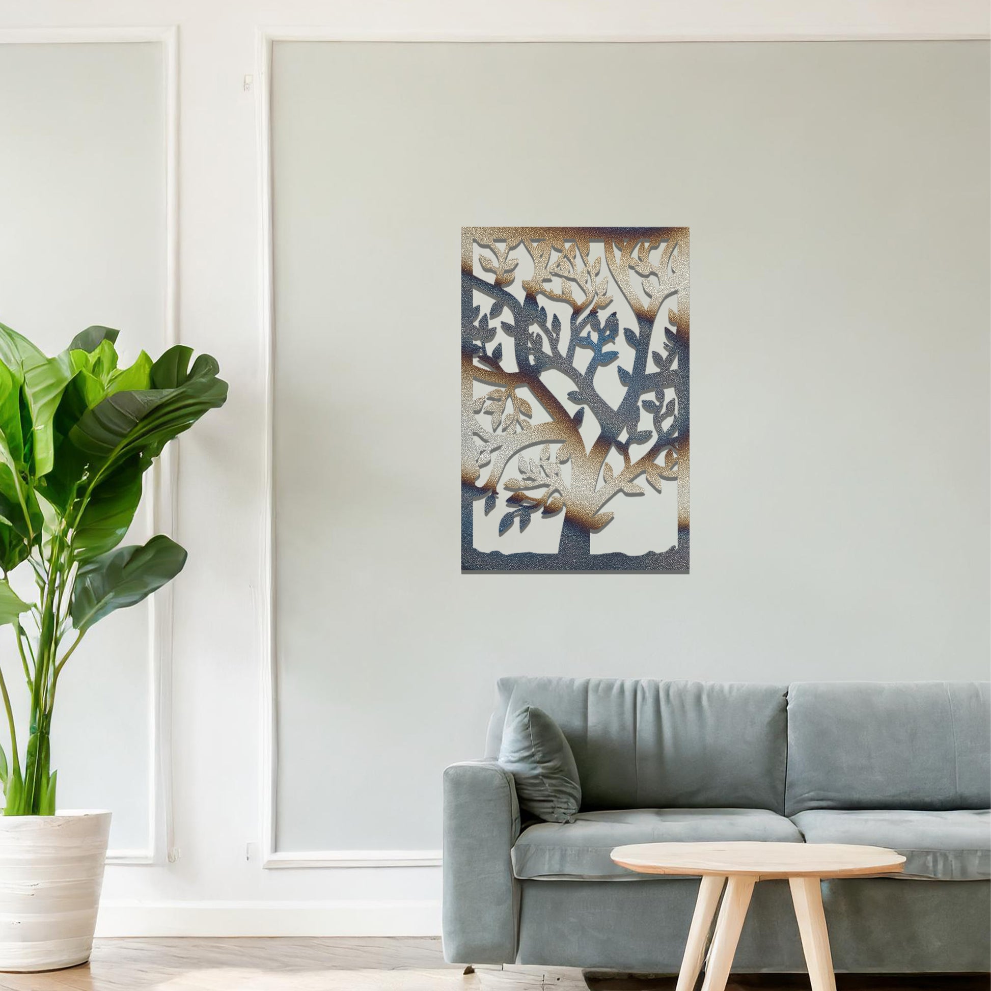 Metal wall art featuring a tree with detailed branches and leaves, enclosed in a rectangular frame. The artwork is displayed on a neutral wall within a modern office space, complemented by a stylish desk, chair, and greenery.