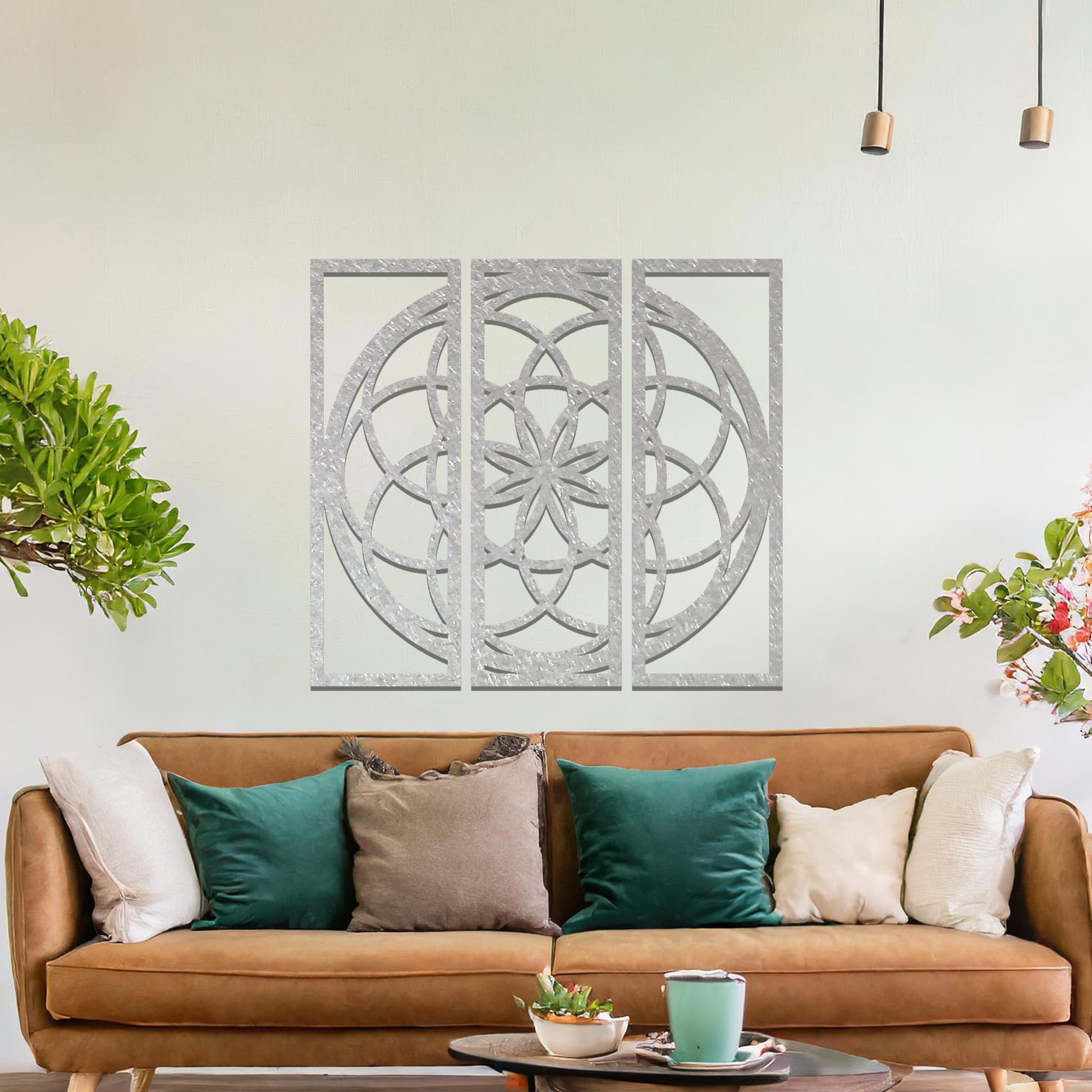 A three-panel metal wall art featuring a geometric floral pattern with interlocking circles and a star-shaped center. The design is displayed on a neutral wall, enhancing the room's modern aesthetic with its elegant symmetry.
