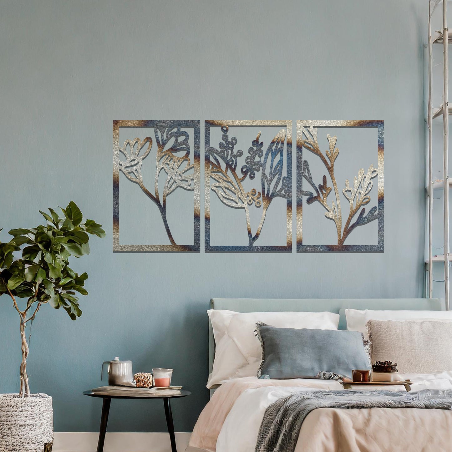 A set of three metal panels featuring intricate botanical designs, with delicate plant shapes in a flowing pattern. The artwork is placed on a neutral wall, enhancing the natural, calming atmosphere of the modern living space.