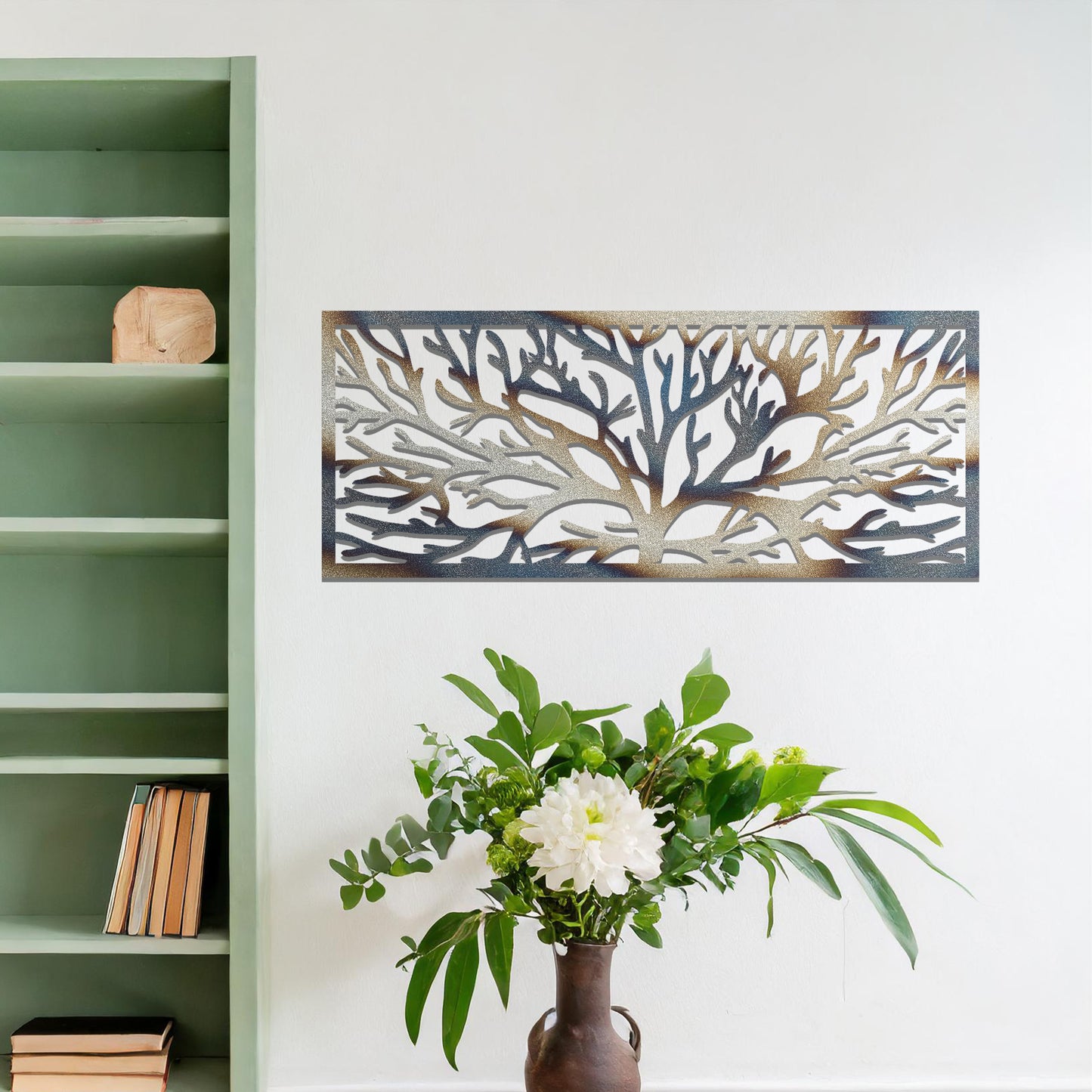 A metal wall art design featuring a detailed tree silhouette with sprawling branches, enclosed in a rectangular frame. The art is displayed on a neutral wall in a modern living room, complementing the contemporary decor and natural elements in the space.