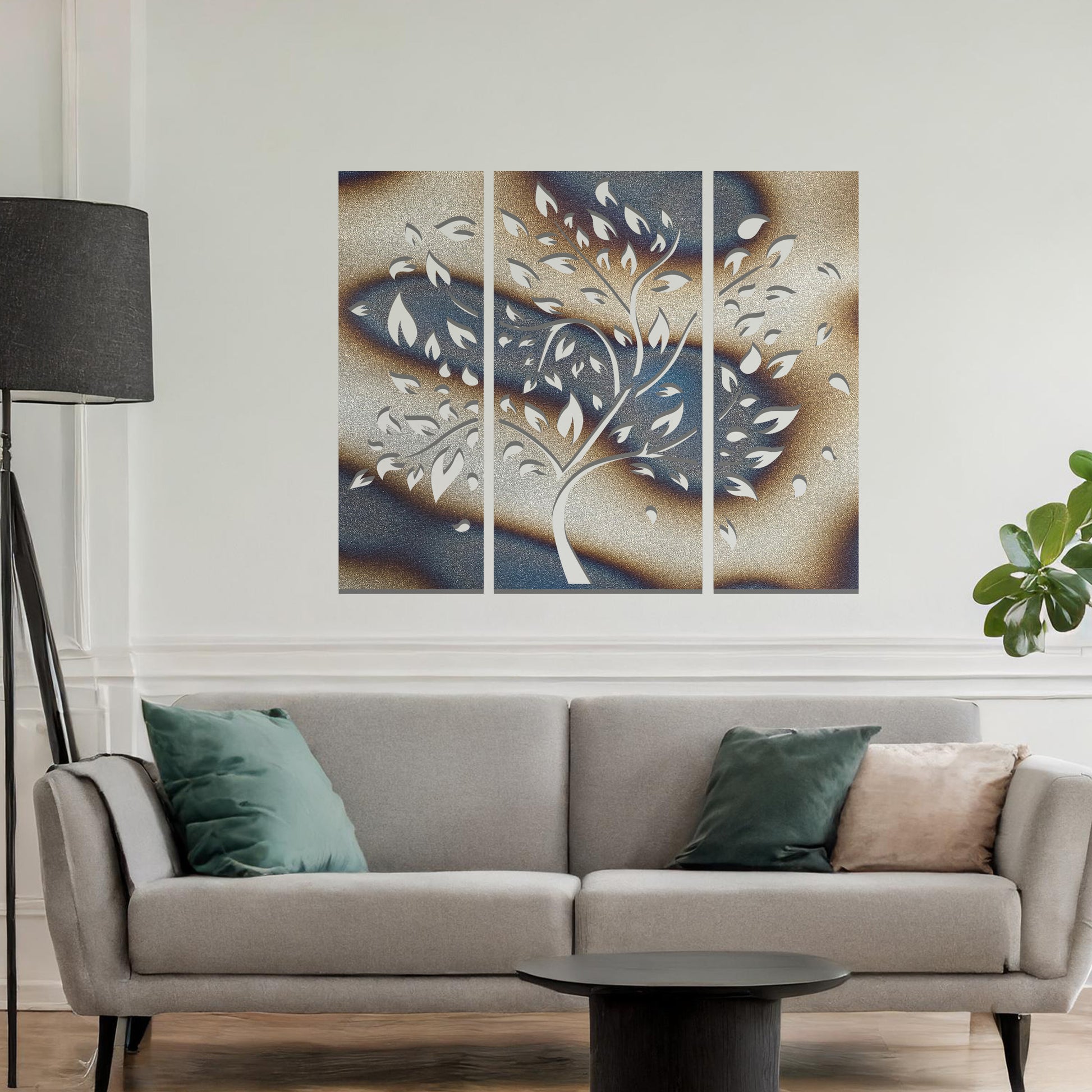 Metal wall art featuring a three-panel tree design with curved branches and delicate leaves, crafted with precise laser-cut detailing, displayed on a neutral wall within modern decor.