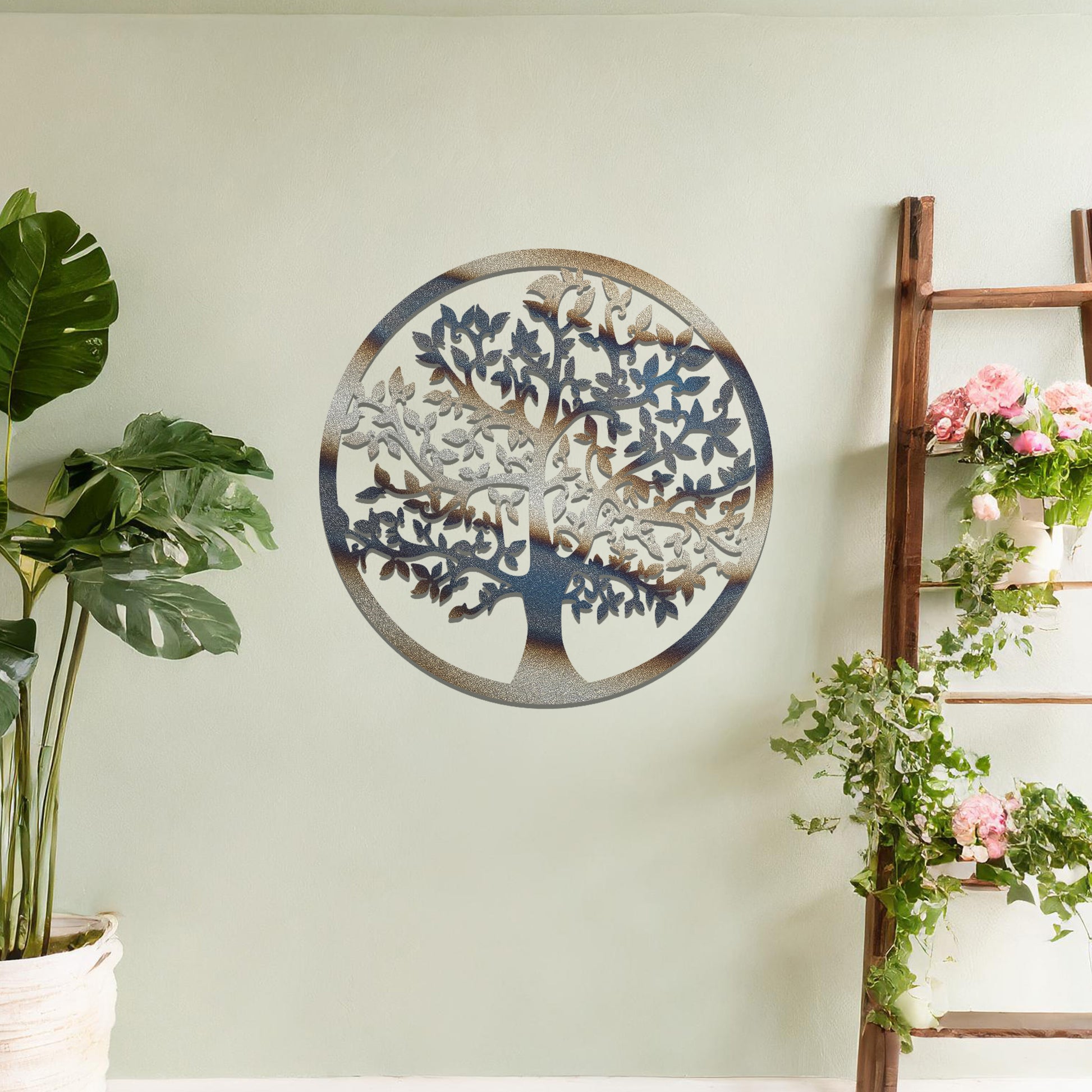 Metal wall art featuring a circular design with a detailed tree of life motif, showcasing intricate branches and leaves, mounted on a neutral wall within modern room decor. The elegant craftsmanship and symbolic design add a touch of sophistication and meaning to the space.