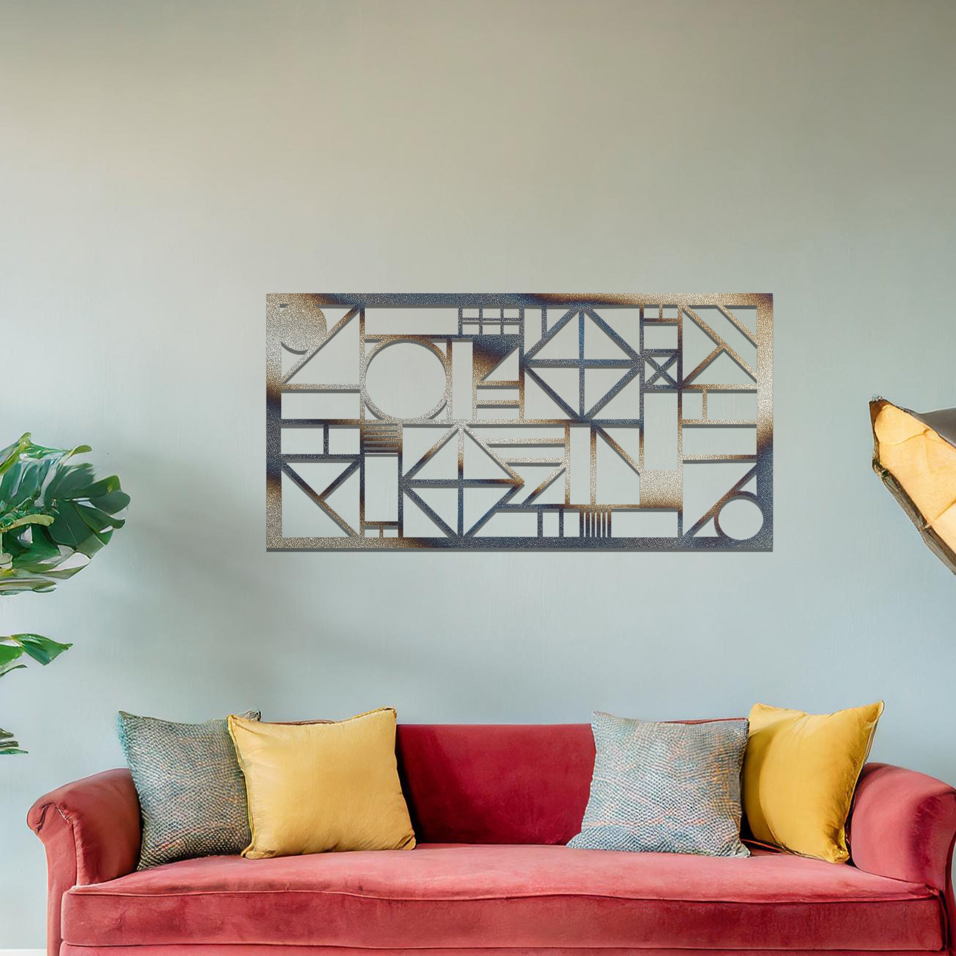 Metal wall art with a geometric design, featuring various abstract shapes, lines, and angles arranged in a structured composition. The art is placed on a neutral wall within modern room decor, adding an artistic touch to the space.