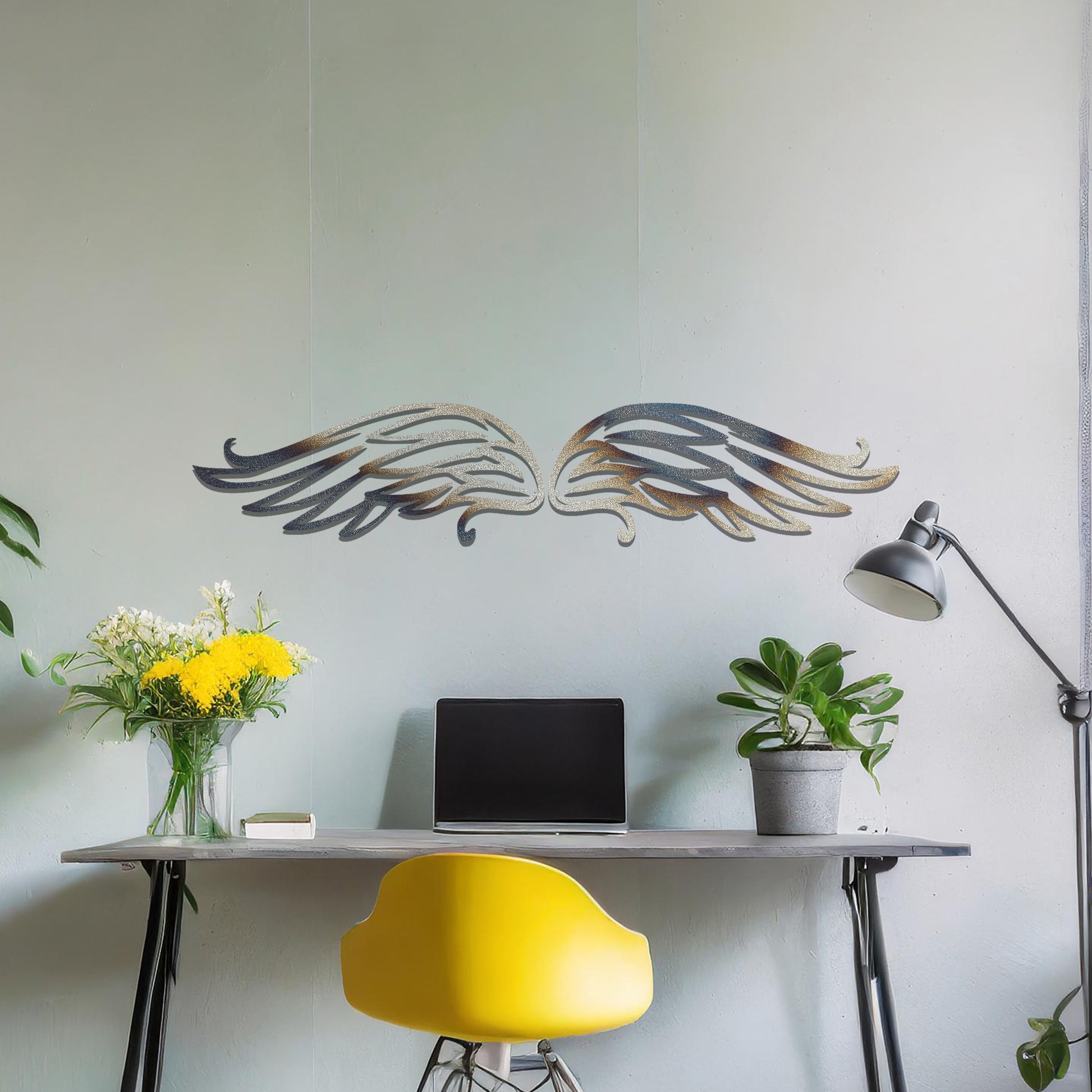 A striking metal wall art design of intricately detailed wings, symmetrically positioned with elegant feather-like lines. The artwork is displayed on a neutral wall within a modern decor setting, adding a touch of sophistication.