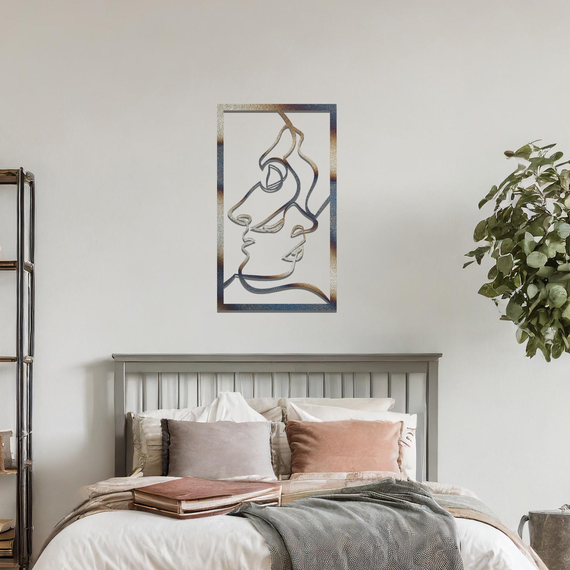 Metal wall art featuring an abstract design of two faces in profile, formed with flowing lines. The art is placed on a neutral wall within a modern office setting, contributing to a stylish and contemporary atmosphere.