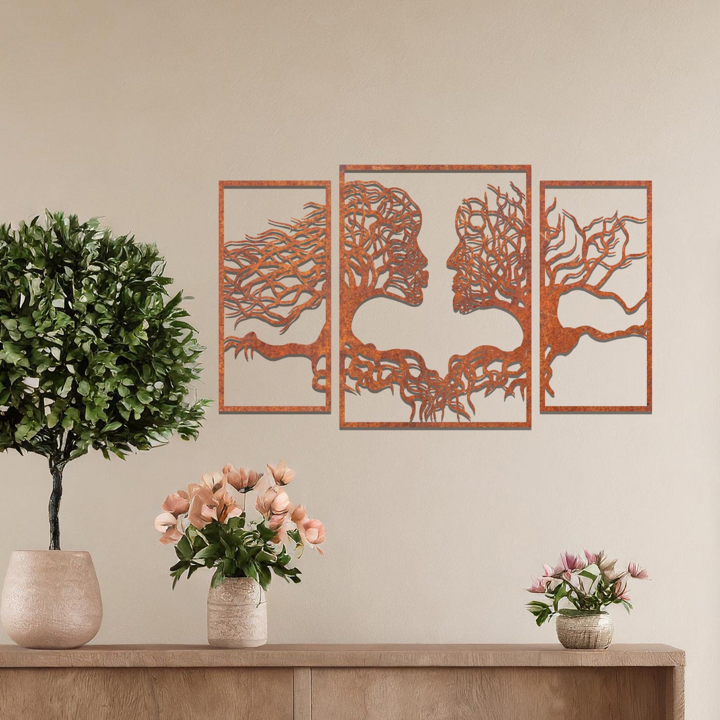 Metal wall art featuring an intricate design of two tree-like figures forming human profiles, crafted with precise laser-cut detailing, framed in panels and placed on a neutral wall within modern decor.