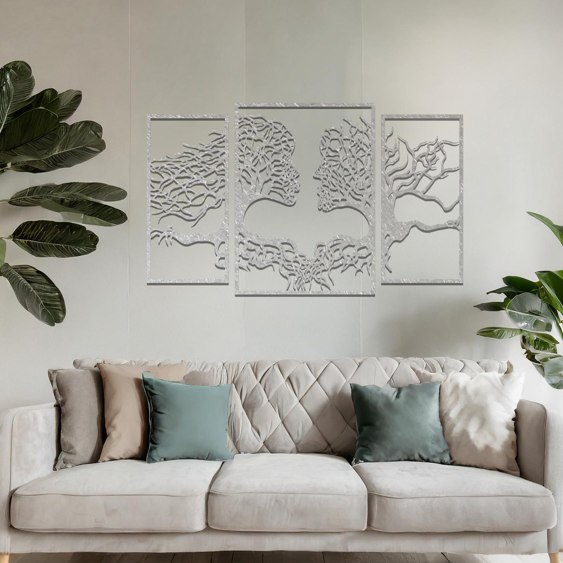 Metal wall art featuring an intricate design of two tree-like figures forming human profiles, crafted with precise laser-cut detailing, framed in panels and placed on a neutral wall within modern decor.
