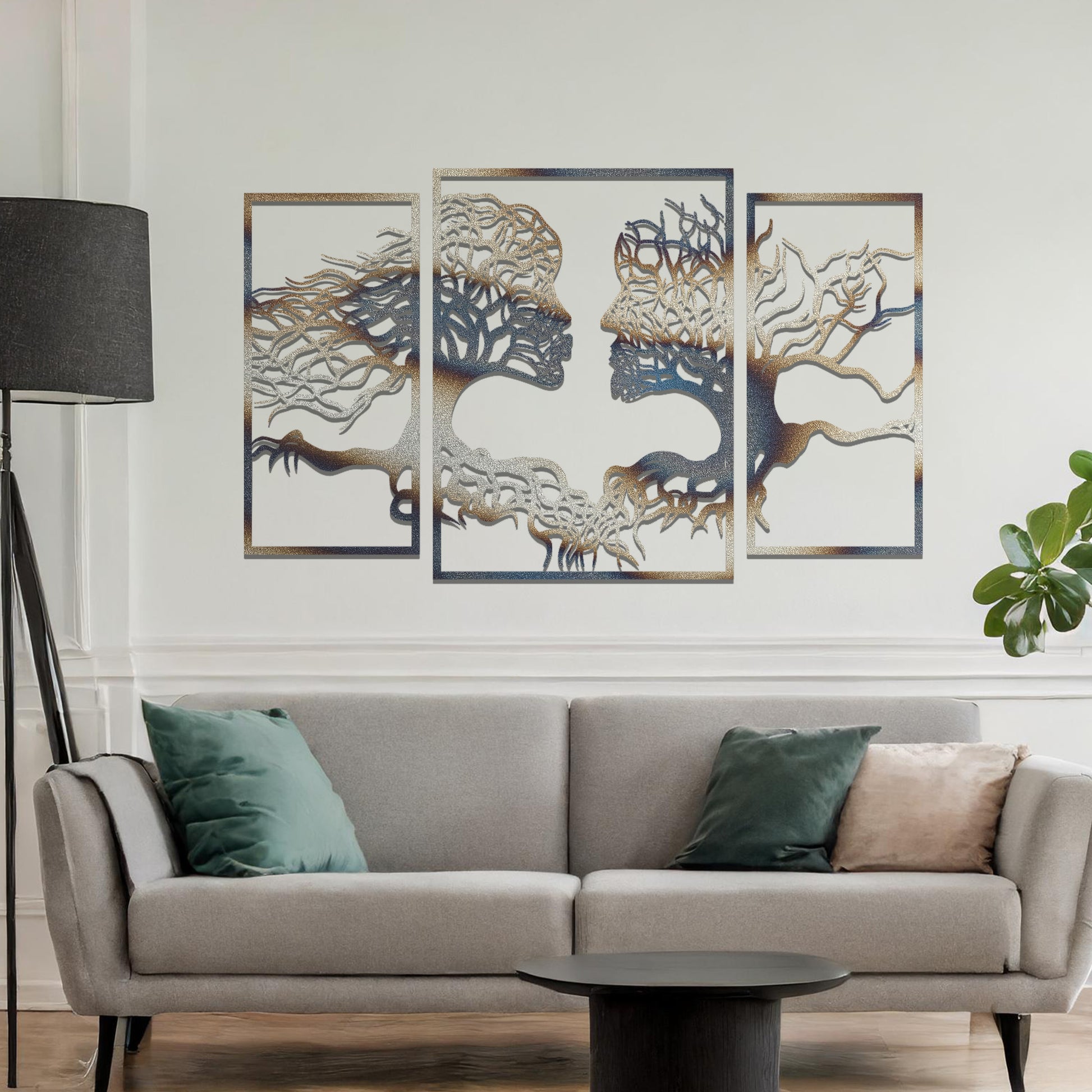 Metal wall art featuring an intricate design of two tree-like figures forming human profiles, crafted with precise laser-cut detailing, framed in panels and placed on a neutral wall within modern decor.