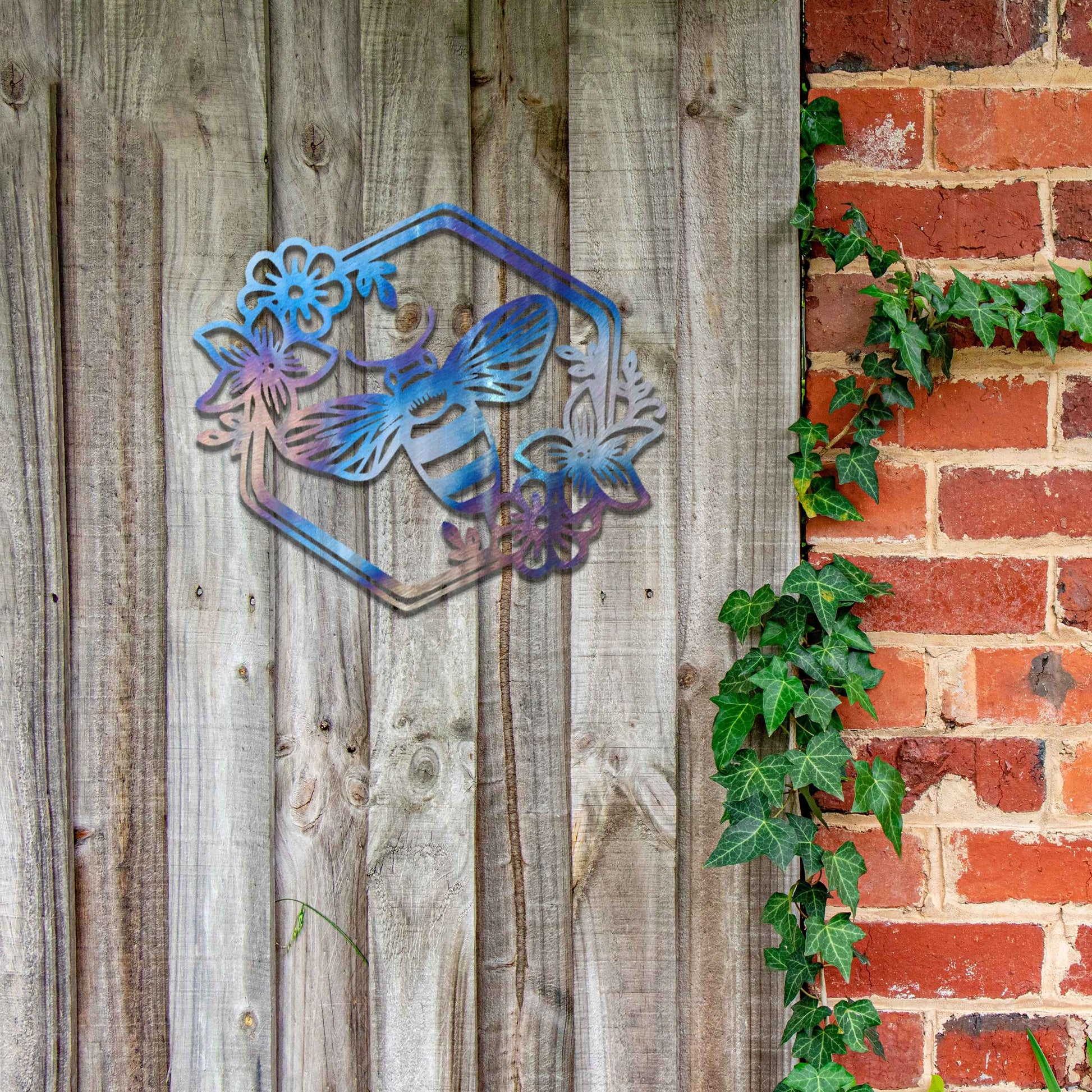 Metal garden decoration showcasing a bee design within a hexagonal frame, adorned with floral details, combining nature-inspired artistry and durability to enhance outdoor spaces with elegance and charm.