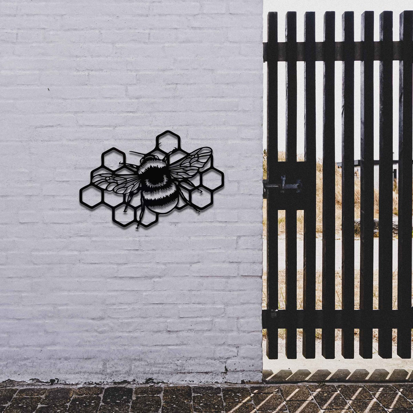 Metal garden decoration featuring a bee on a honeycomb design, showcasing intricate detailing in the wings and honeycomb structure, perfect for enhancing outdoor spaces with a nature-inspired artistic touch.