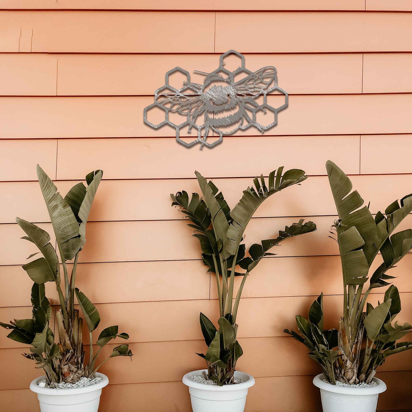 Metal garden decoration featuring a bee on a honeycomb design, showcasing intricate detailing in the wings and honeycomb structure, perfect for enhancing outdoor spaces with a nature-inspired artistic touch.