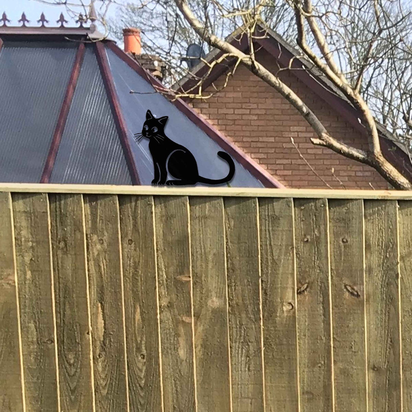 Metal garden decoration featuring a sitting cat silhouette with a rustic finish, designed to adorn fence tops or garden posts, adding a charming and playful touch to outdoor spaces.