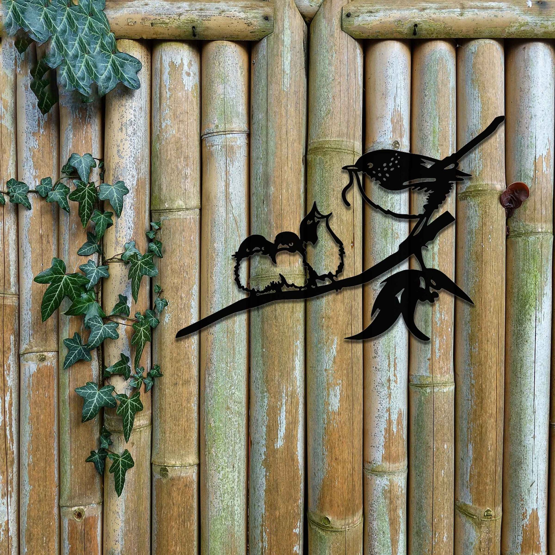 Metal wall art featuring a bird perched on a branch with two smaller birds sitting closely together, crafted in a rustic finish. This piece brings a touch of nature-inspired charm to indoor or outdoor spaces.