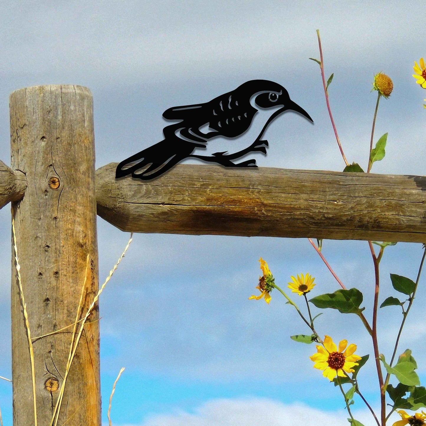 Metal garden decoration featuring a bird silhouette with intricate cutout details, adding a sleek and modern touch to outdoor spaces, designed to sit gracefully on fence posts or wooden beams.