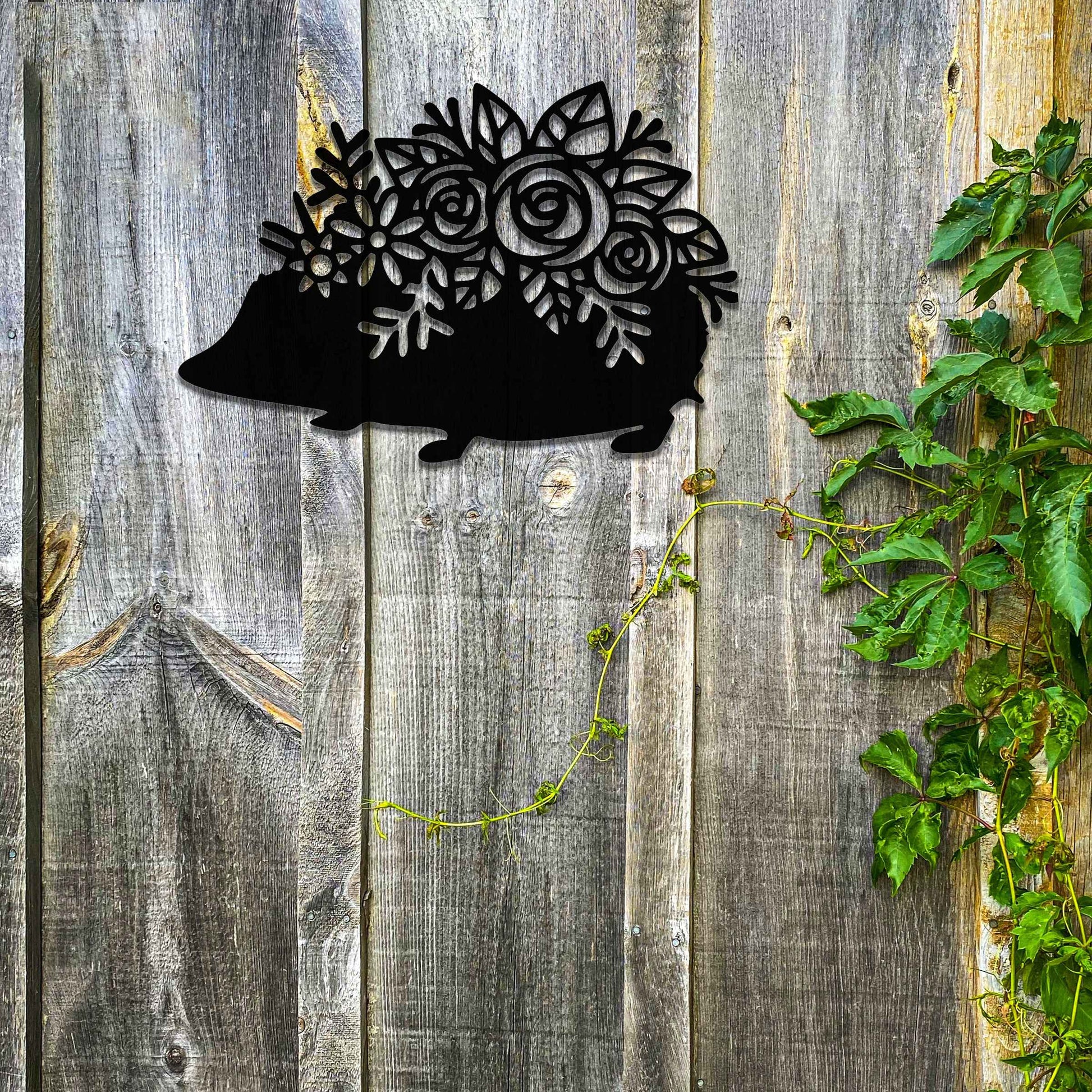 Metal garden decoration featuring a hedgehog-shaped design with intricate floral cutouts, adding a charming and rustic touch to outdoor spaces, perfectly blending with garden greenery.