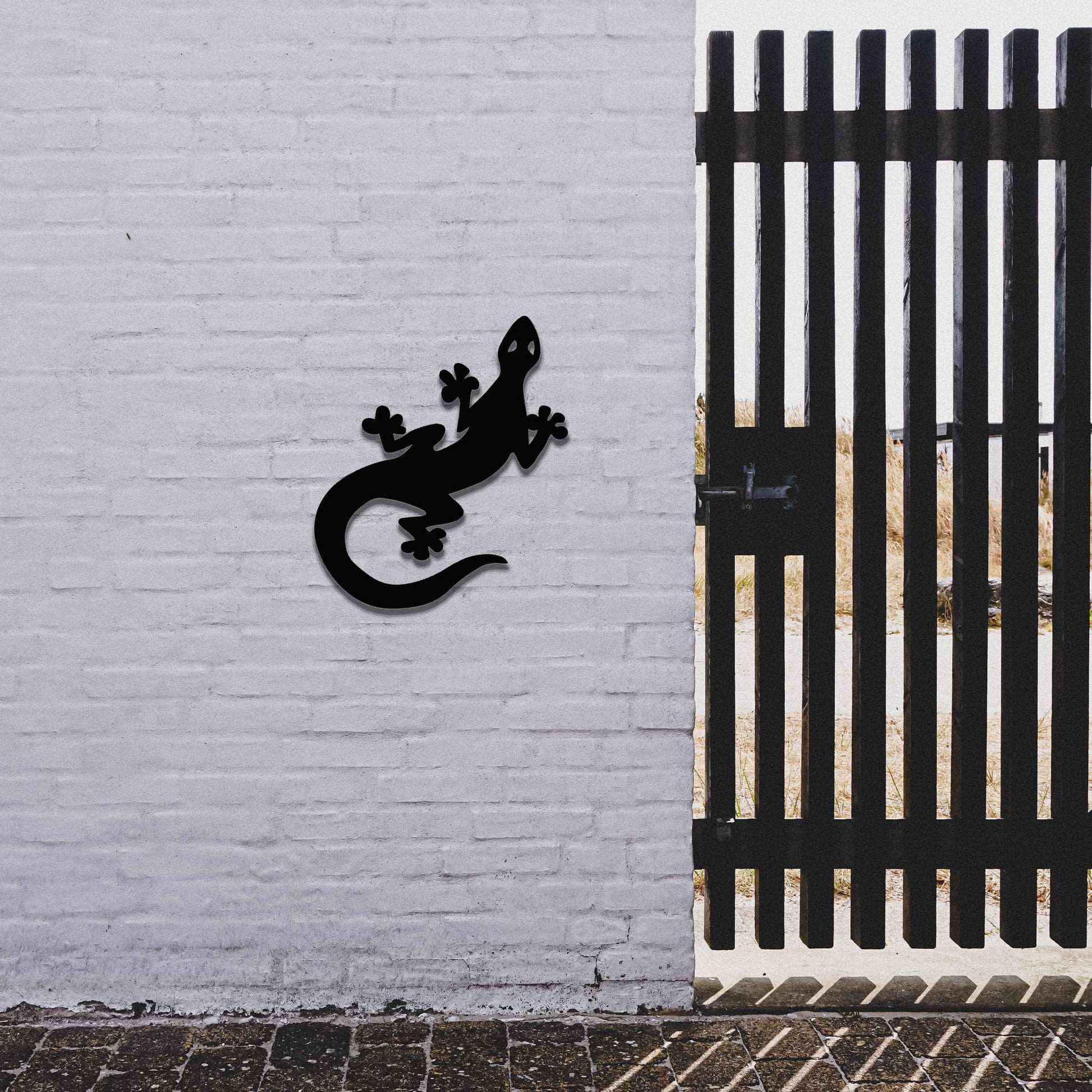 Metal garden decoration featuring a playful gecko silhouette with distinct rounded feet and curved tail, adding a modern and lively touch to outdoor walls, perfectly suited for rustic and contemporary garden settings.