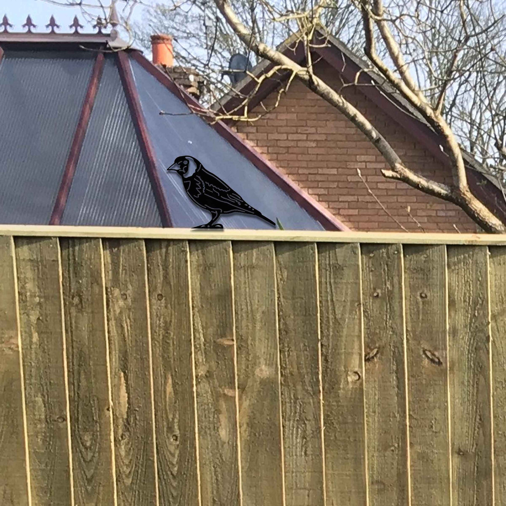 Metal garden decoration featuring a bird silhouette with a rustic finish, designed to sit atop fences or garden structures, adding a natural and artistic accent to outdoor spaces.
