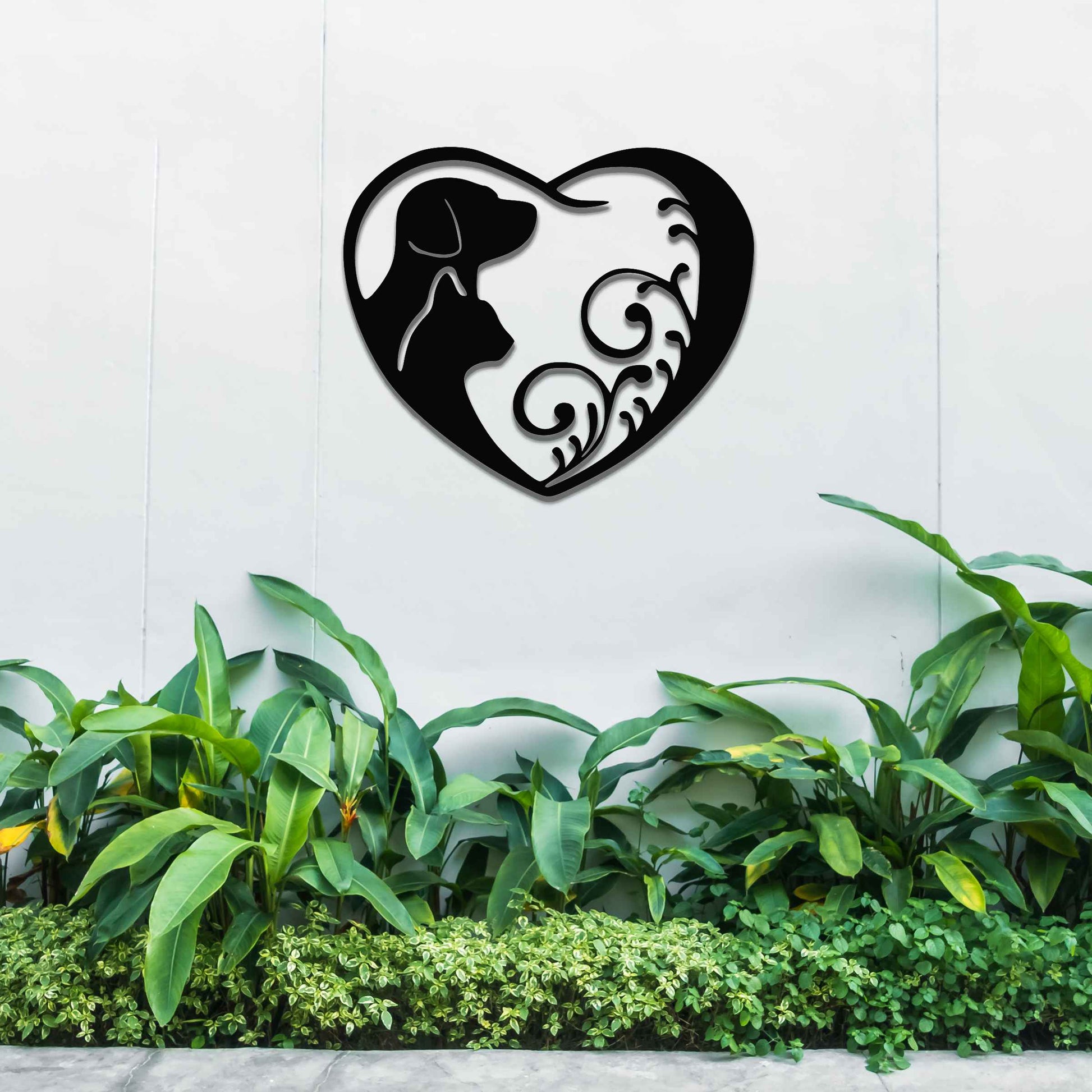 Metal garden decoration featuring a heart-shaped design with silhouettes of a dog and cat intertwined with elegant scrollwork, symbolising love for pets and adding a decorative charm to outdoor walls or garden spaces.