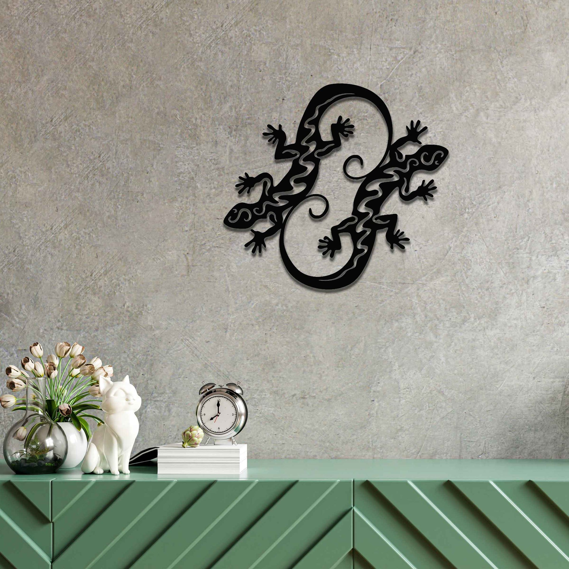 Metal wall decoration featuring two intertwined gecko designs with flowing and curved patterns, adding a dynamic and modern artistic touch to indoor spaces, displayed on a neutral wall within contemporary decor.