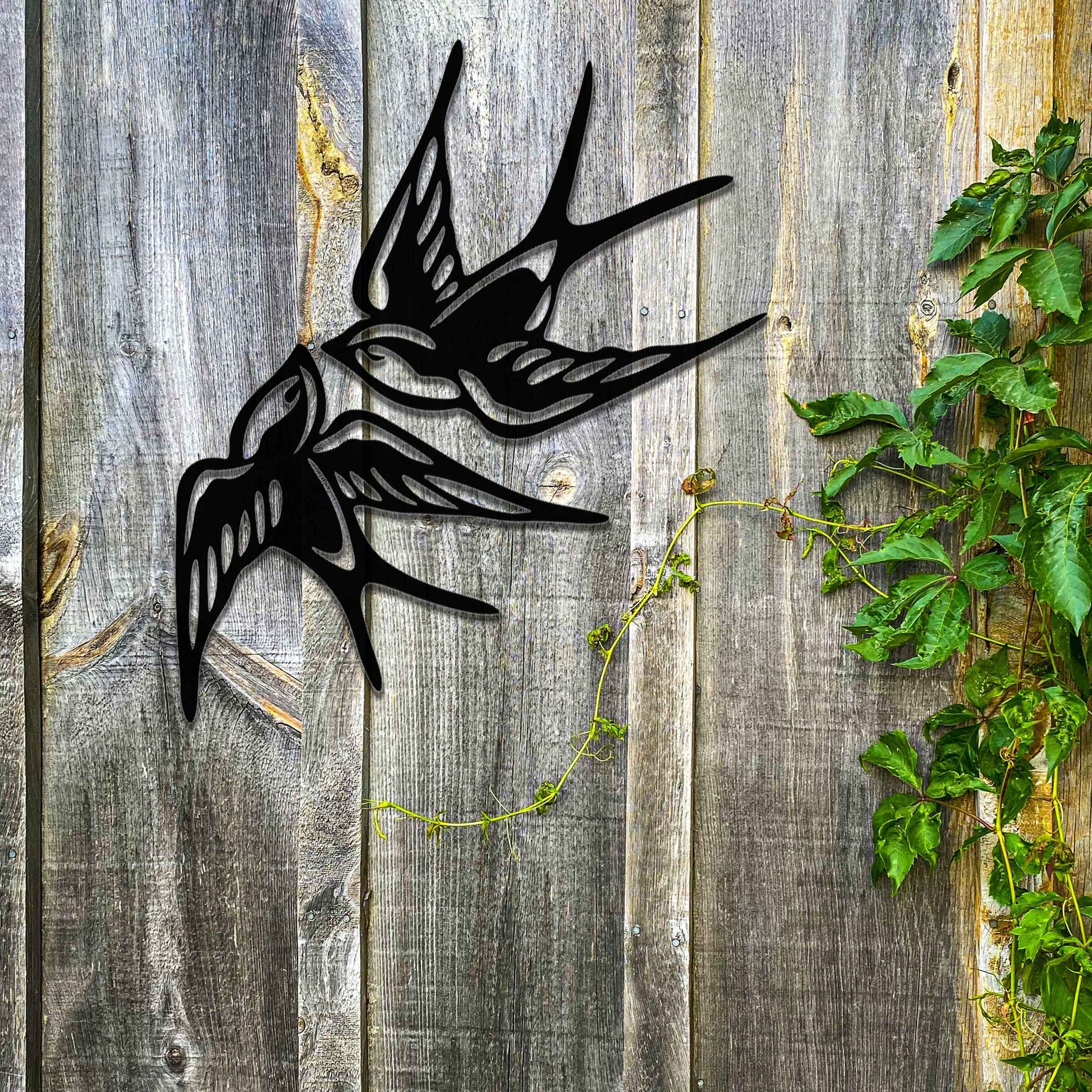 Metal garden decoration featuring a pair of swallows in flight, crafted with intricate detailing and a rustic finish, adding a graceful and timeless charm to outdoor walls or garden spaces.