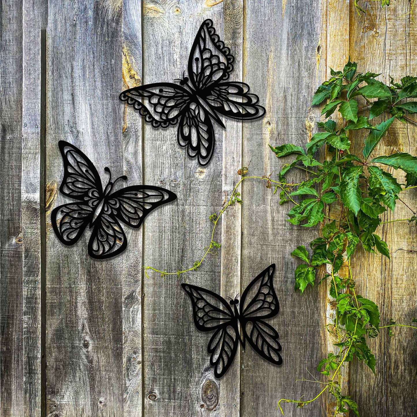 Set of metal garden decorations featuring three intricately designed butterflies with a rustic finish, adding a graceful and nature-inspired aesthetic to outdoor walls or garden spaces.