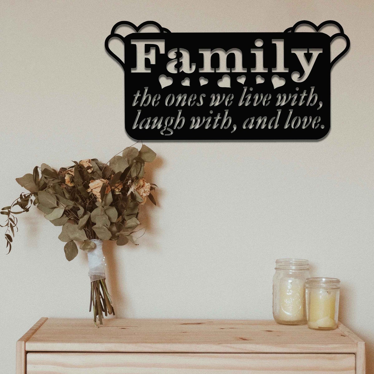 Metal wall decoration featuring the word "Family" and the phrase "the ones we live with, laugh with, and love," accented with heart details, adding a heartfelt and meaningful touch to indoor or outdoor spaces.