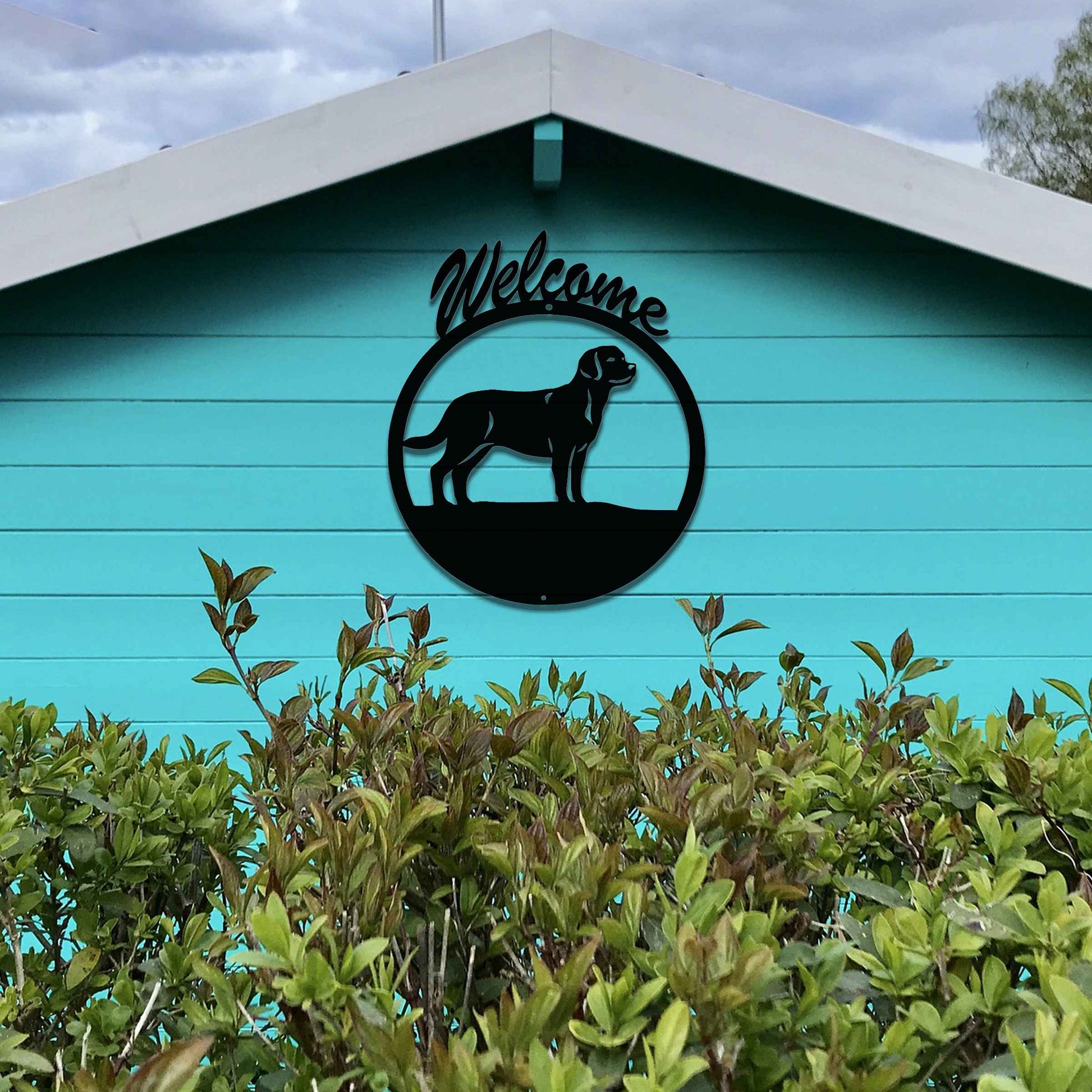 Metal garden art design showcasing a dog silhouette in profile, enclosed within a circular frame. Above the dog, the word Welcome is displayed, creating a warm and inviting atmosphere.