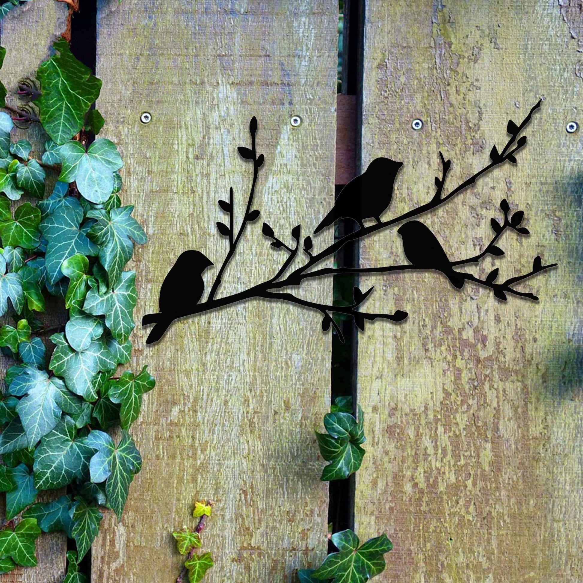 Metal garden decoration featuring three birds perched on a leafy branch, crafted with intricate cutout details and a rustic finish, adding a charming and natural touch to outdoor walls or garden spaces.