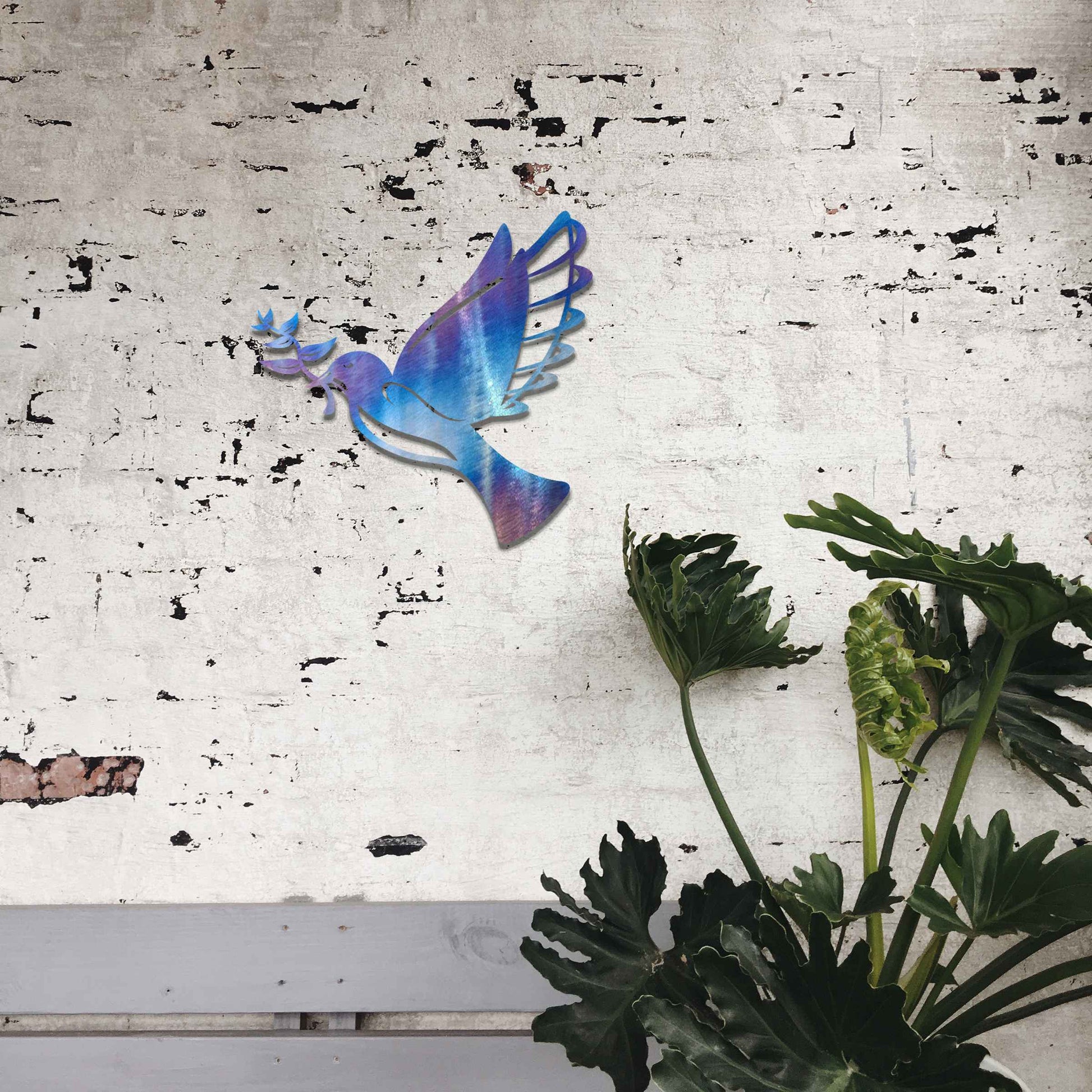 Metal garden decoration featuring a dove in flight holding an olive branch, crafted with a rustic finish, symbolising peace and harmony while adding a touch of elegance and meaning to outdoor spaces.