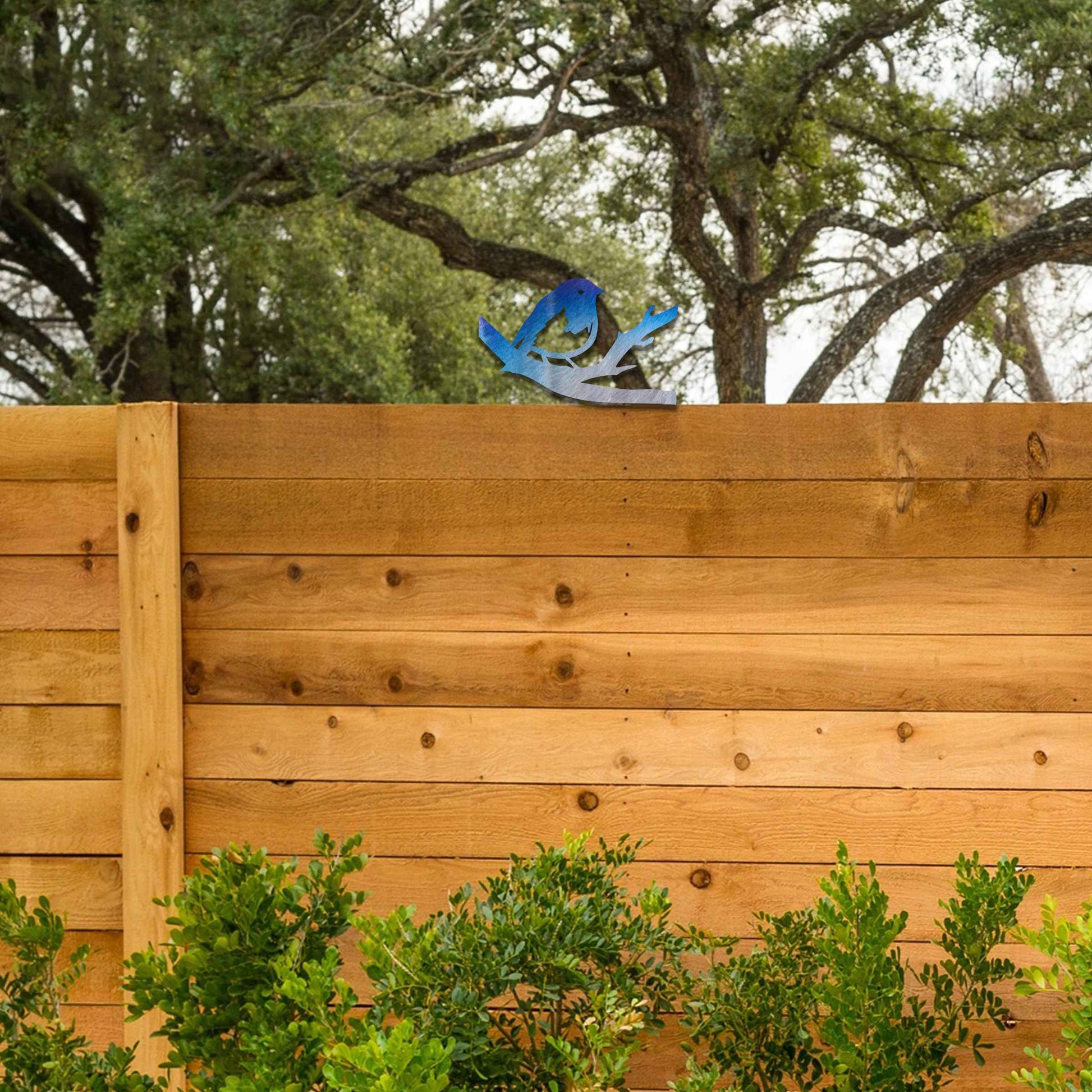Metal garden decoration featuring a bird perched on a branch with intricate cutout details and a rustic finish, designed to adorn wooden posts or beams, adding a charming and natural accent to outdoor spaces.