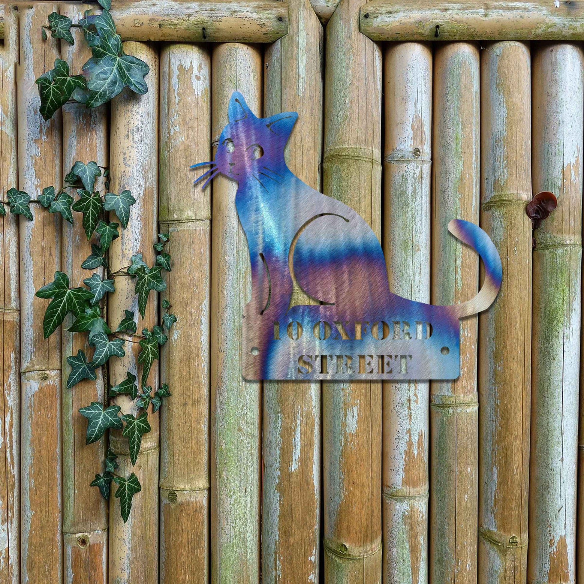 Metal garden decoration featuring a sleek sitting cat silhouette with a personalised address plaque, combining practicality with artistic charm for outdoor walls, fences, or gates.