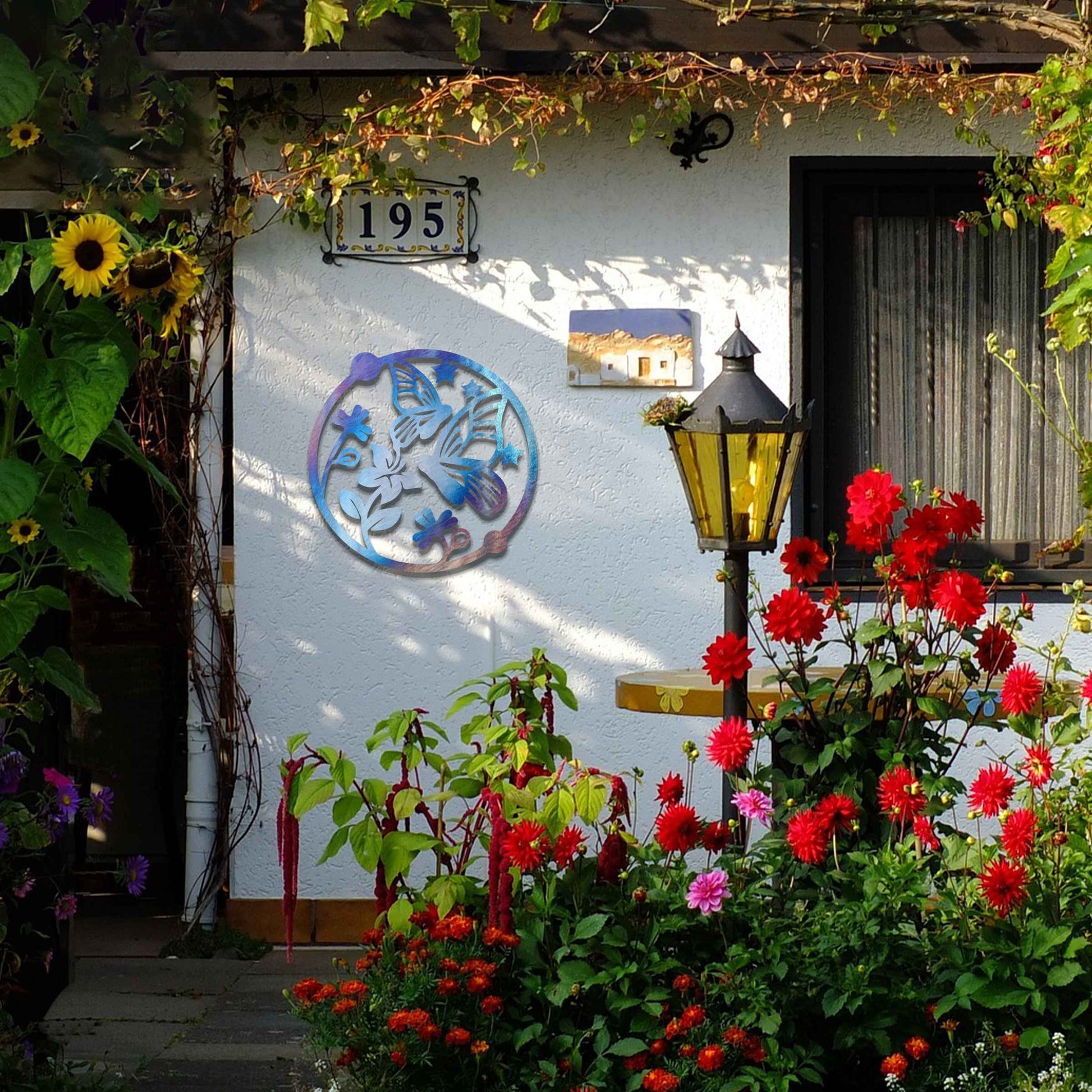 Metal garden decoration featuring a circular design with butterflies, flowers, and stars, crafted with a rustic finish, adding a whimsical and nature-inspired charm to outdoor walls or fences.