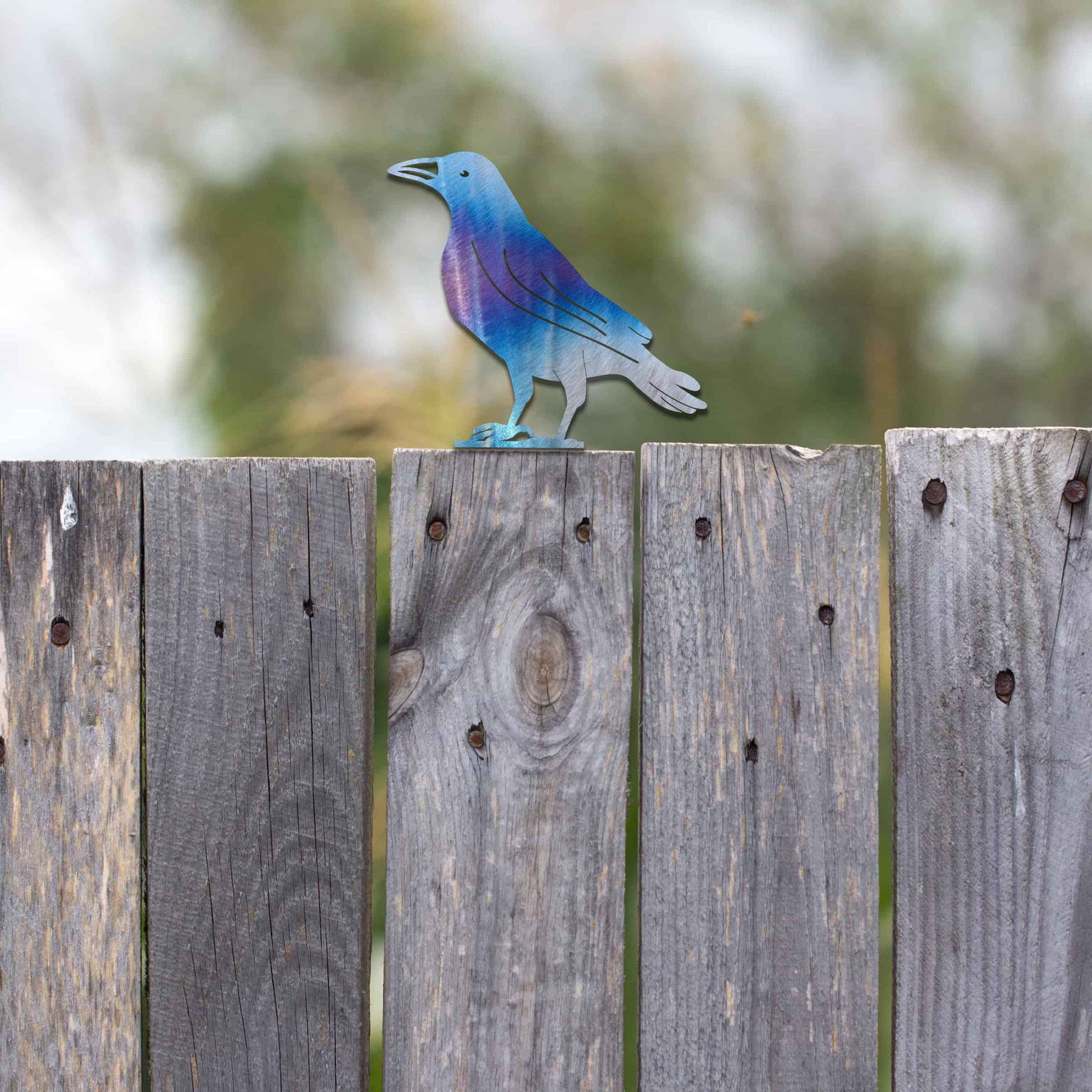 Metal garden decoration featuring a crow silhouette with a rustic finish, designed to sit atop fences or garden posts, adding a bold and distinctive touch to outdoor spaces.
