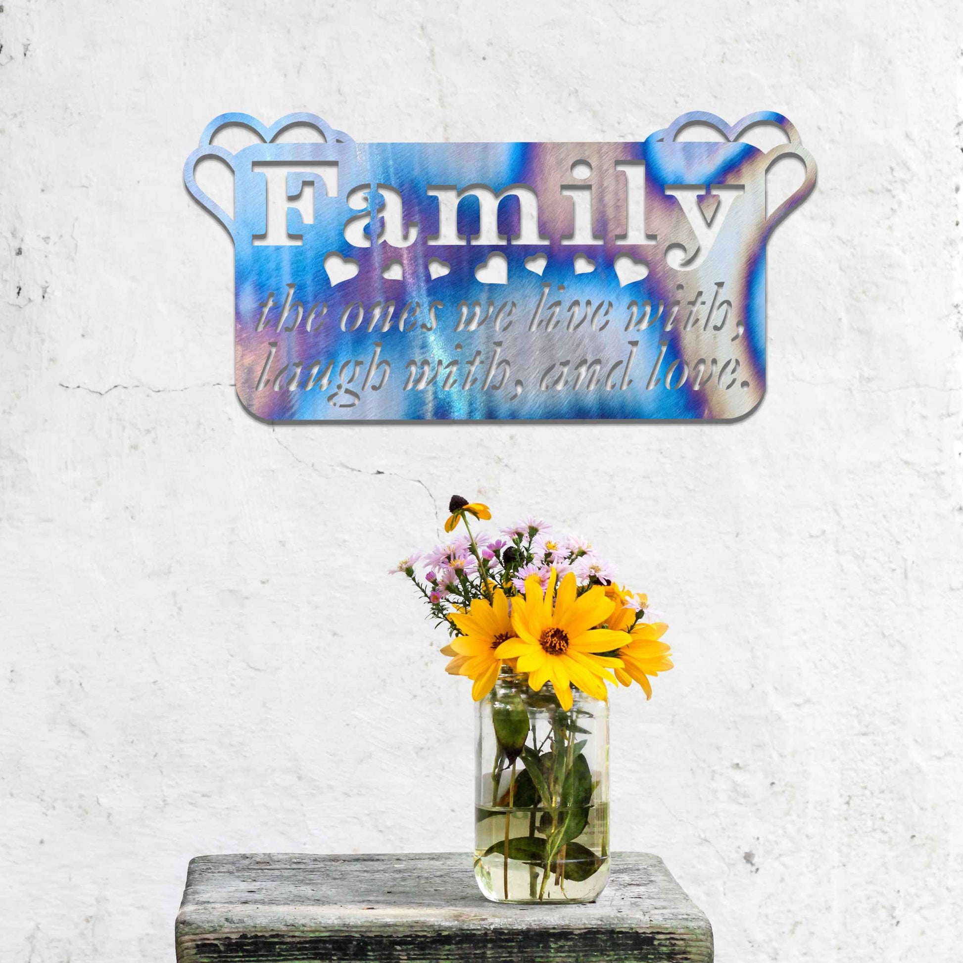 Metal wall decoration featuring the word "Family" and the phrase "the ones we live with, laugh with, and love," accented with heart details, adding a heartfelt and meaningful touch to indoor or outdoor spaces.