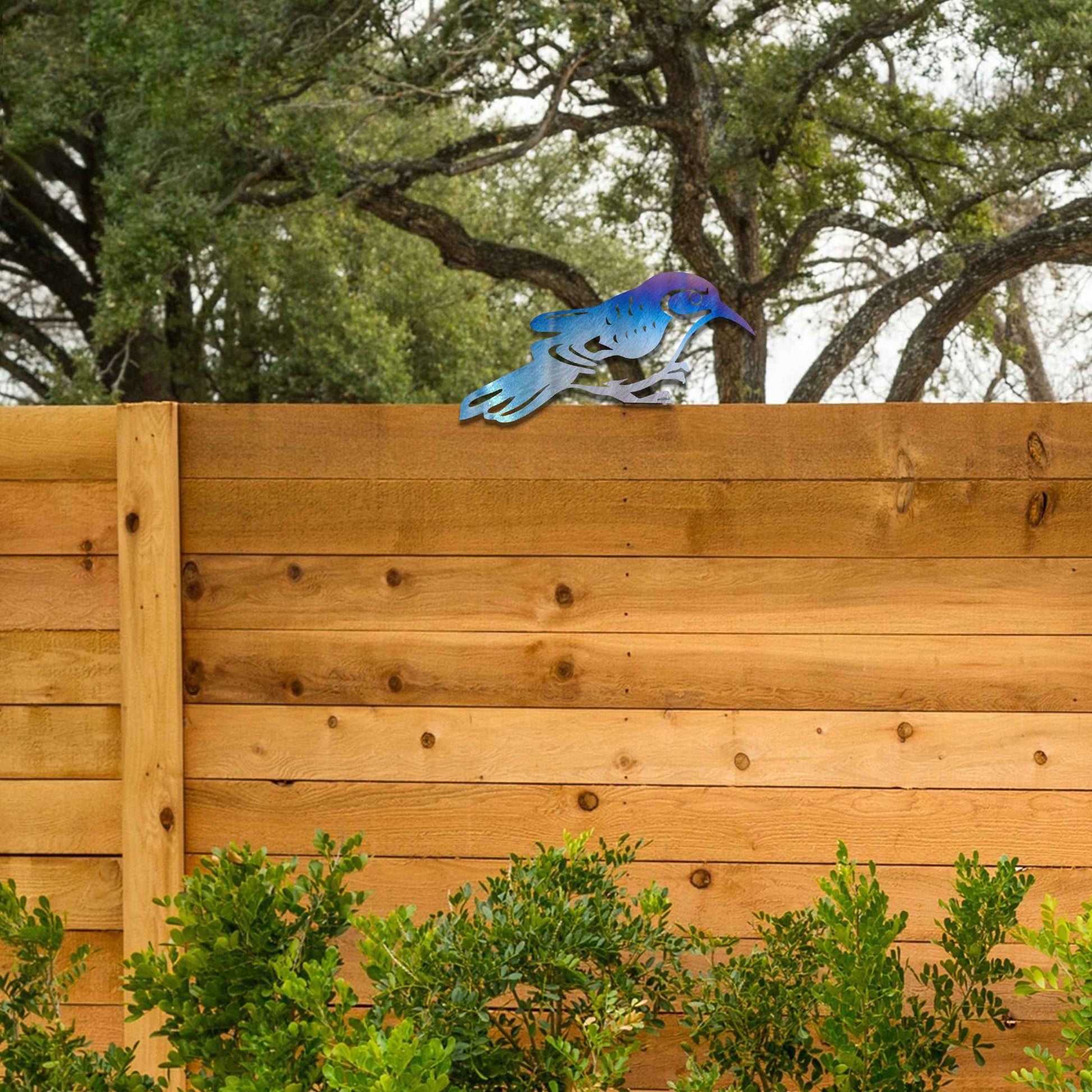 Metal garden decoration featuring a bird silhouette with intricate cutout details, adding a sleek and modern touch to outdoor spaces, designed to sit gracefully on fence posts or wooden beams.