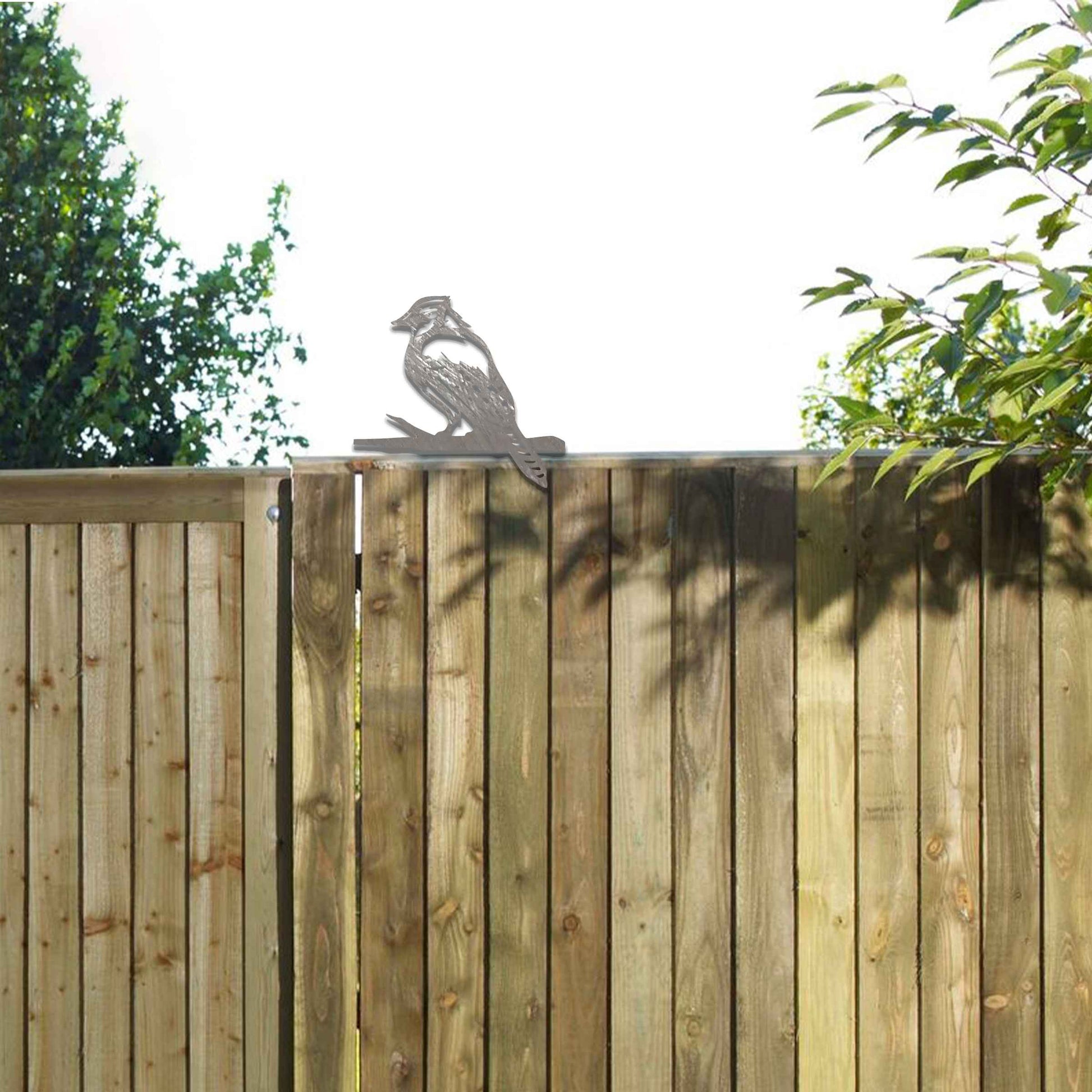Metal garden decoration featuring a woodpecker silhouette with intricate cutout details and a rustic finish, designed to perch on wooden beams or posts, adding a natural and artistic touch to outdoor spaces.
