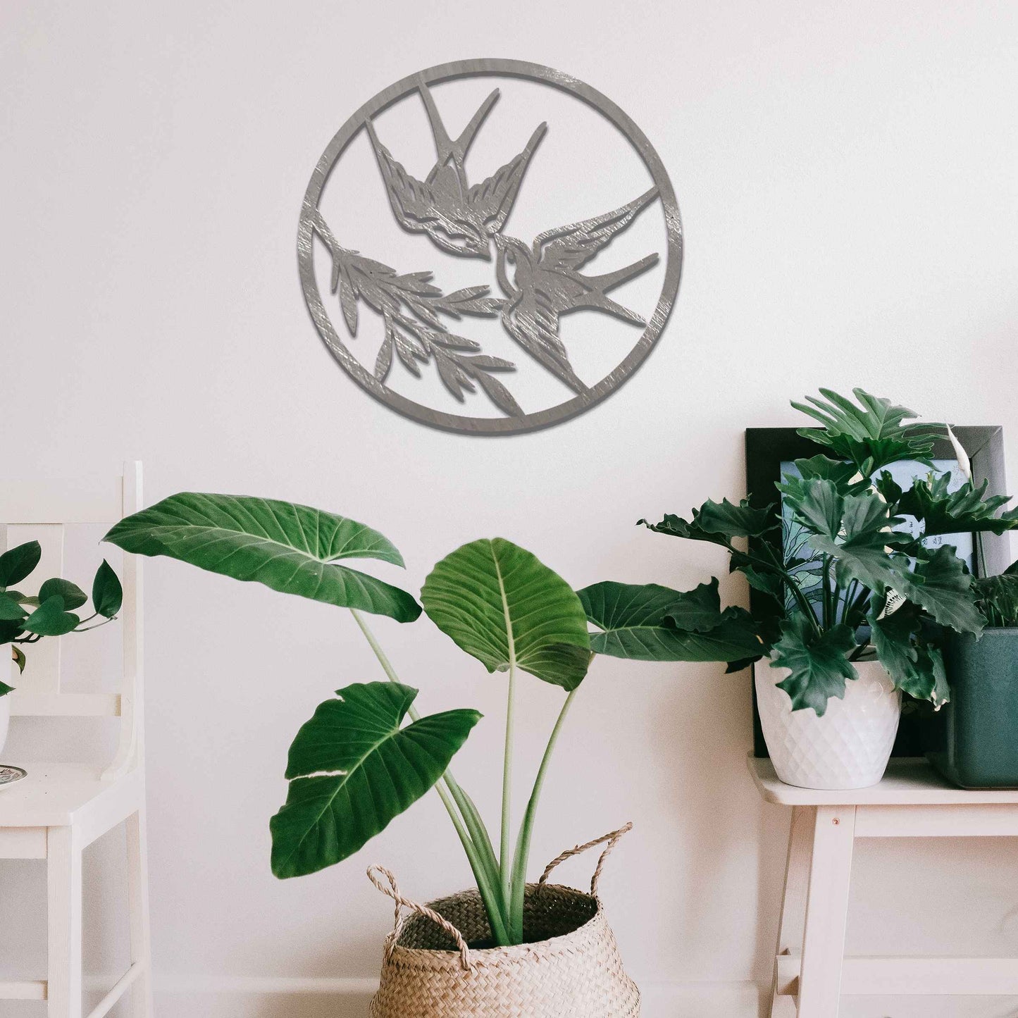 Metal garden decoration featuring two swallows in flight within a circular frame, accented by delicate branch details, combining nature-inspired elegance and craftsmanship to enhance outdoor or indoor spaces.