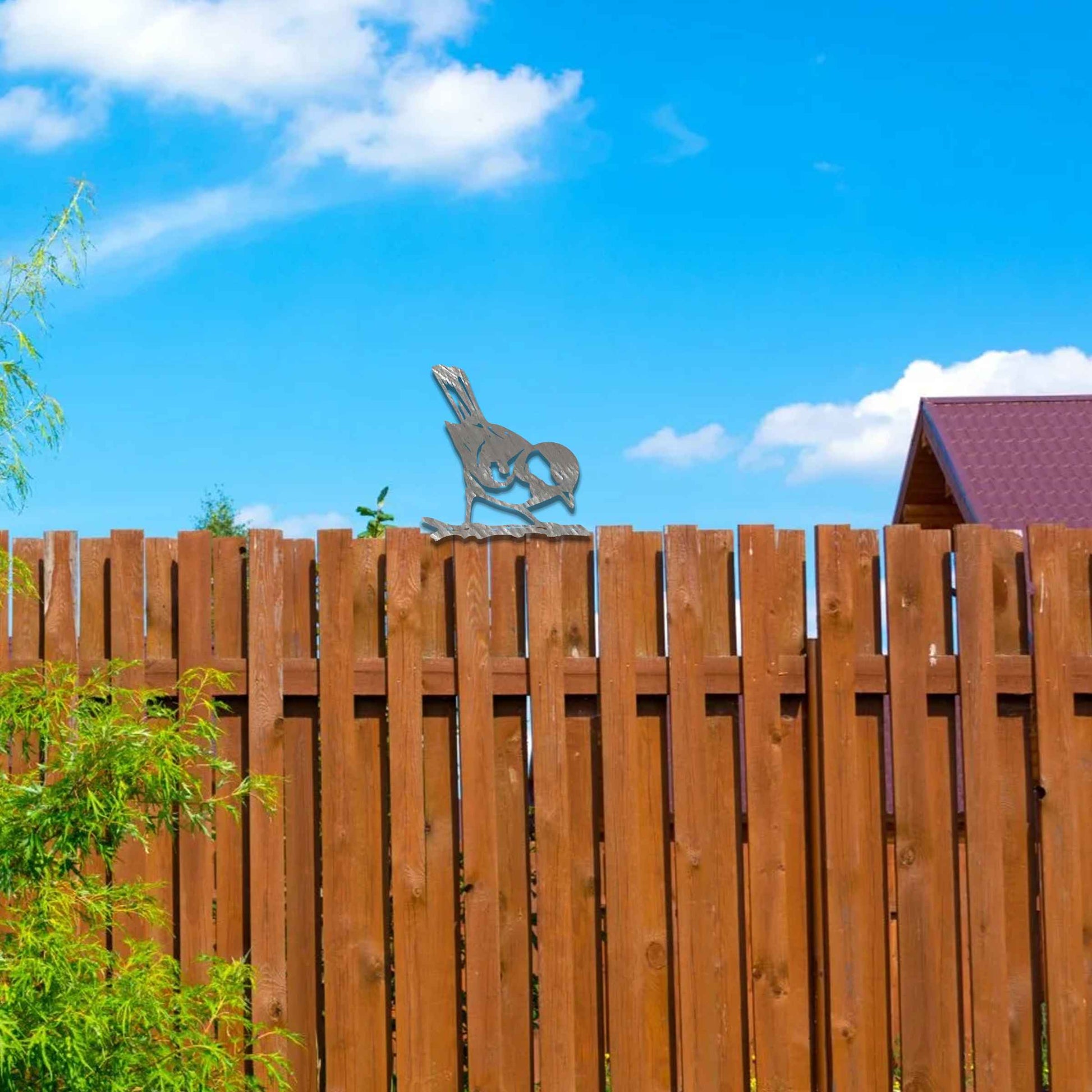 Metal garden decoration featuring a bird silhouette with a rustic finish, perched on a branch, designed to enhance fence tops or wooden posts, adding a natural and charming touch to outdoor spaces.