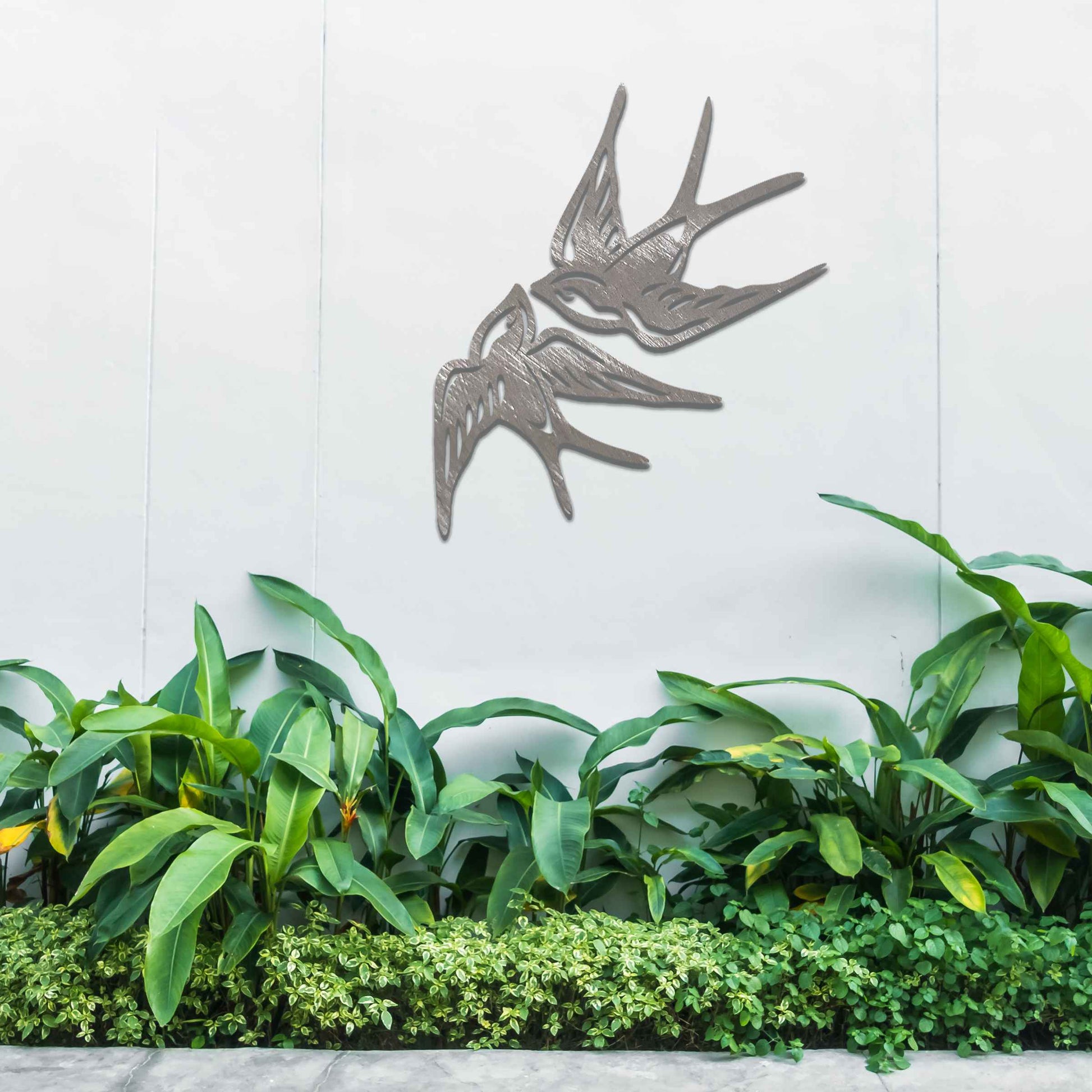 Metal garden decoration featuring a pair of swallows in flight, crafted with intricate detailing and a rustic finish, adding a graceful and timeless charm to outdoor walls or garden spaces.