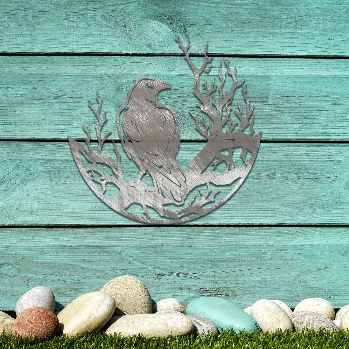 Metal wall decoration featuring a crow perched on detailed tree branches within a circular frame, crafted with intricate cutouts and a rustic finish, adding a bold and artistic touch to indoor or outdoor spaces.