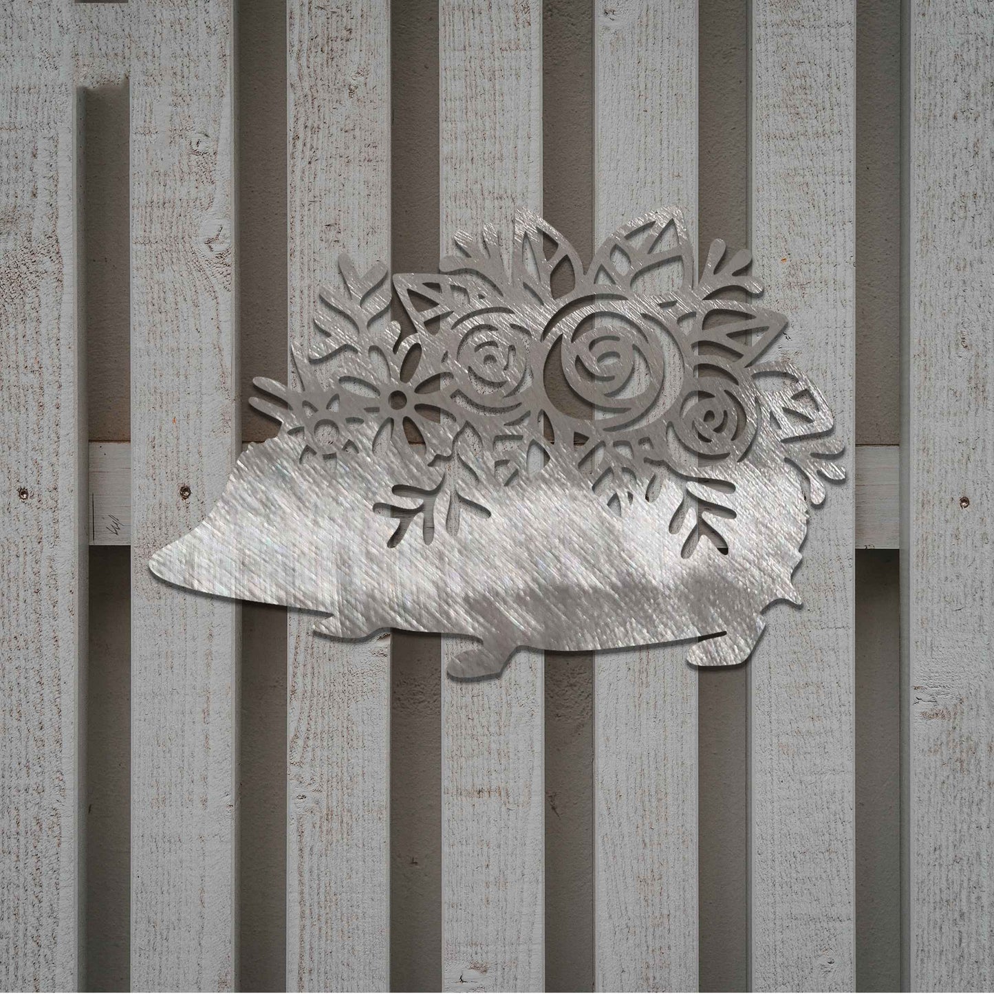 Metal garden decoration featuring a hedgehog-shaped design with intricate floral cutouts, adding a charming and rustic touch to outdoor spaces, perfectly blending with garden greenery.