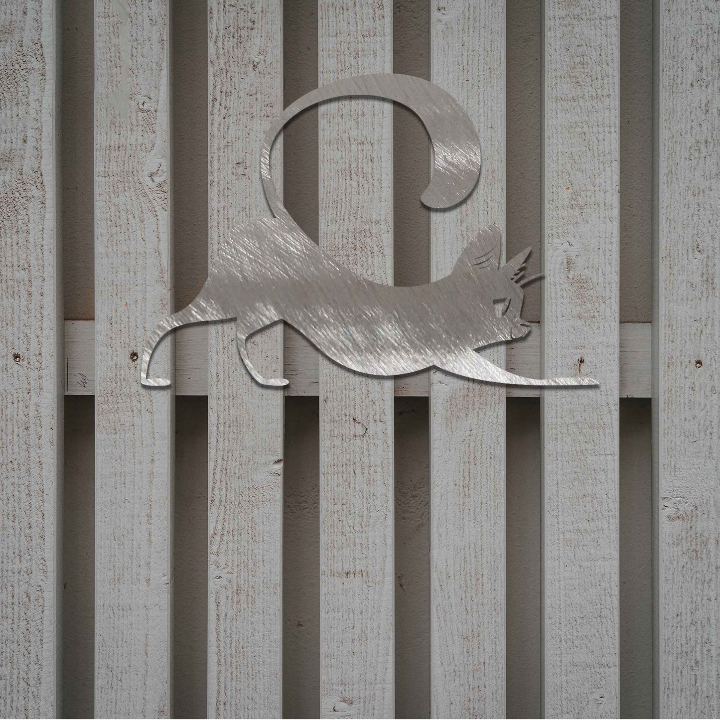 Metal garden decoration featuring a playful cat stretching with its tail curved upwards, crafted with sleek and elegant detailing, adding a touch of charm and liveliness to outdoor walls, fences, or doors.