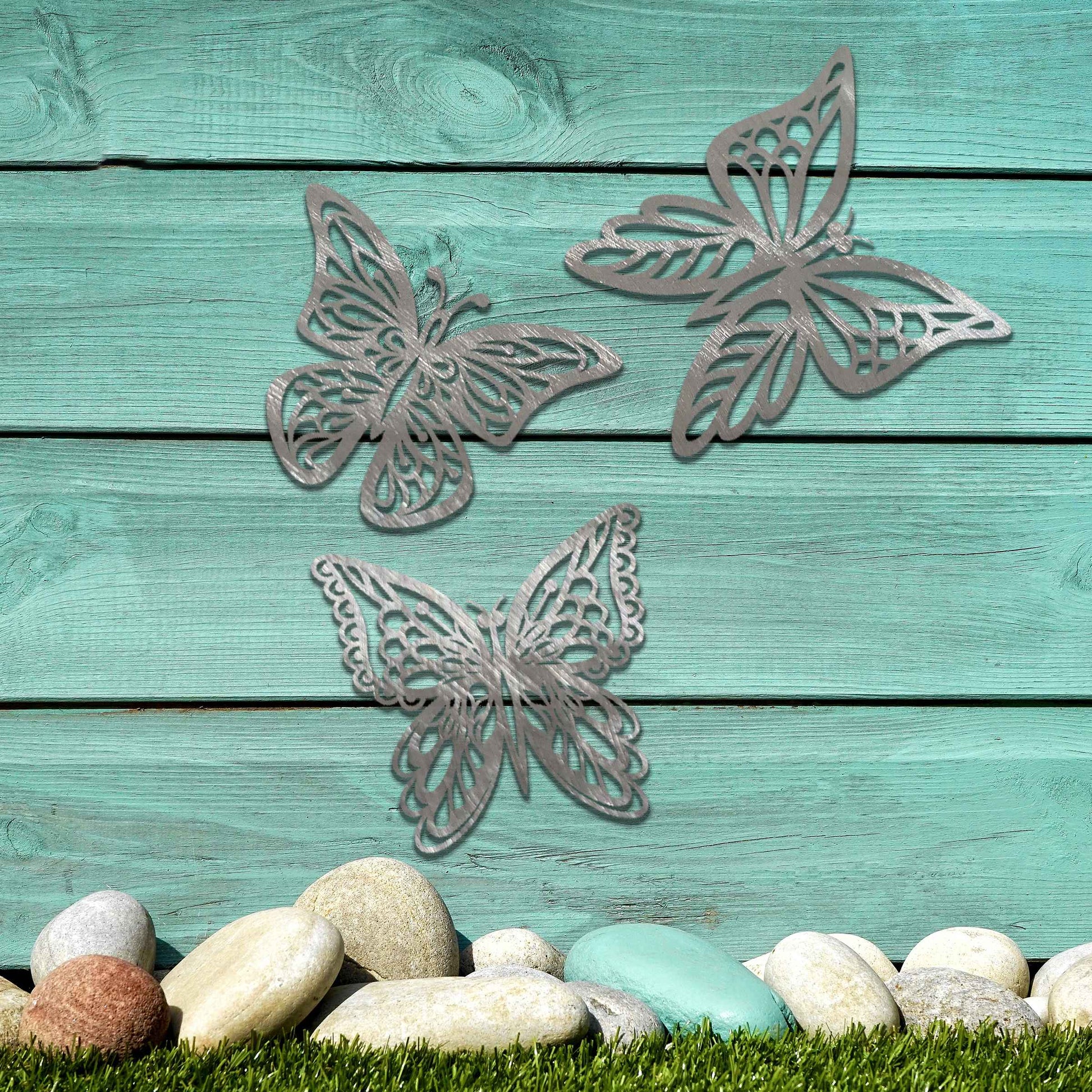 Set of metal garden decorations featuring three intricately designed butterflies with a rustic finish, adding a graceful and nature-inspired aesthetic to outdoor walls or garden spaces.