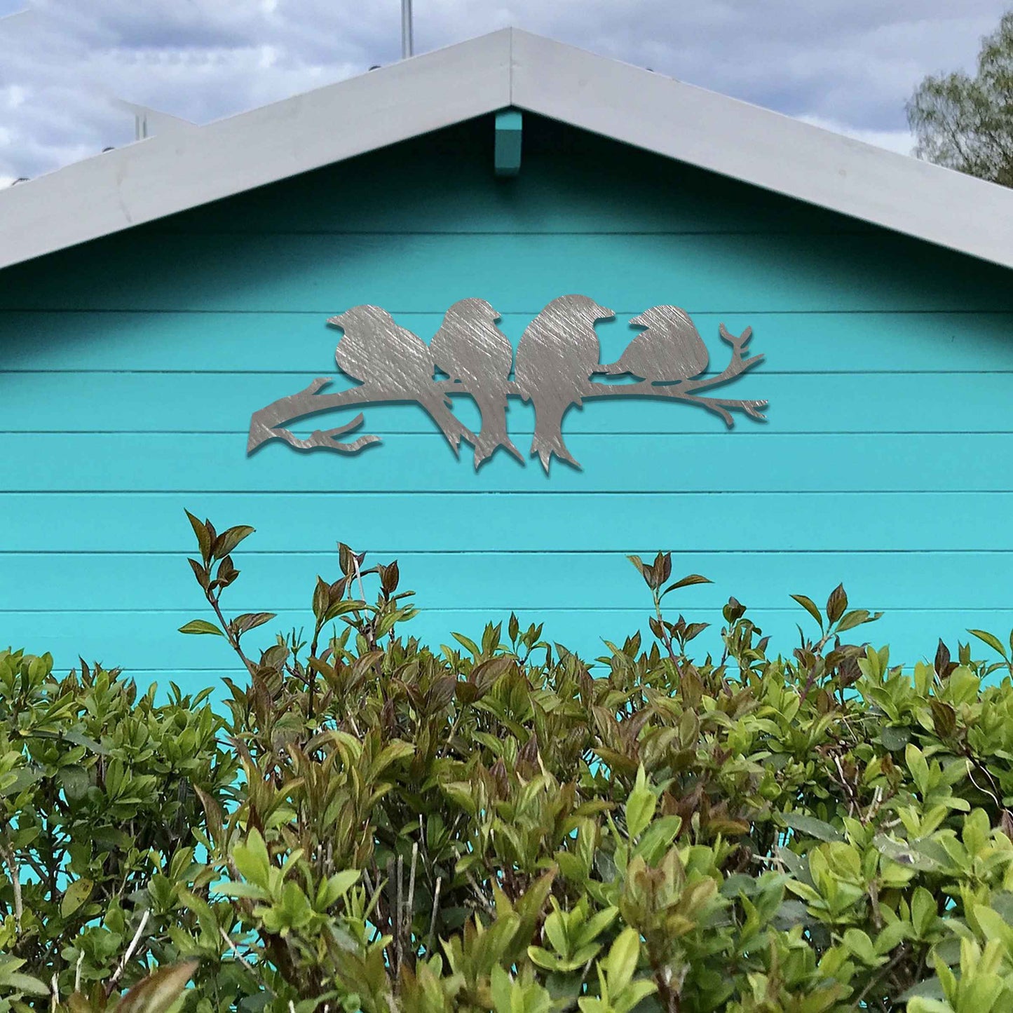 Metal garden decoration featuring four birds sitting on a branch, crafted with intricate cutout details and a rustic finish, adding a delightful and natural charm to outdoor walls or garden spaces.