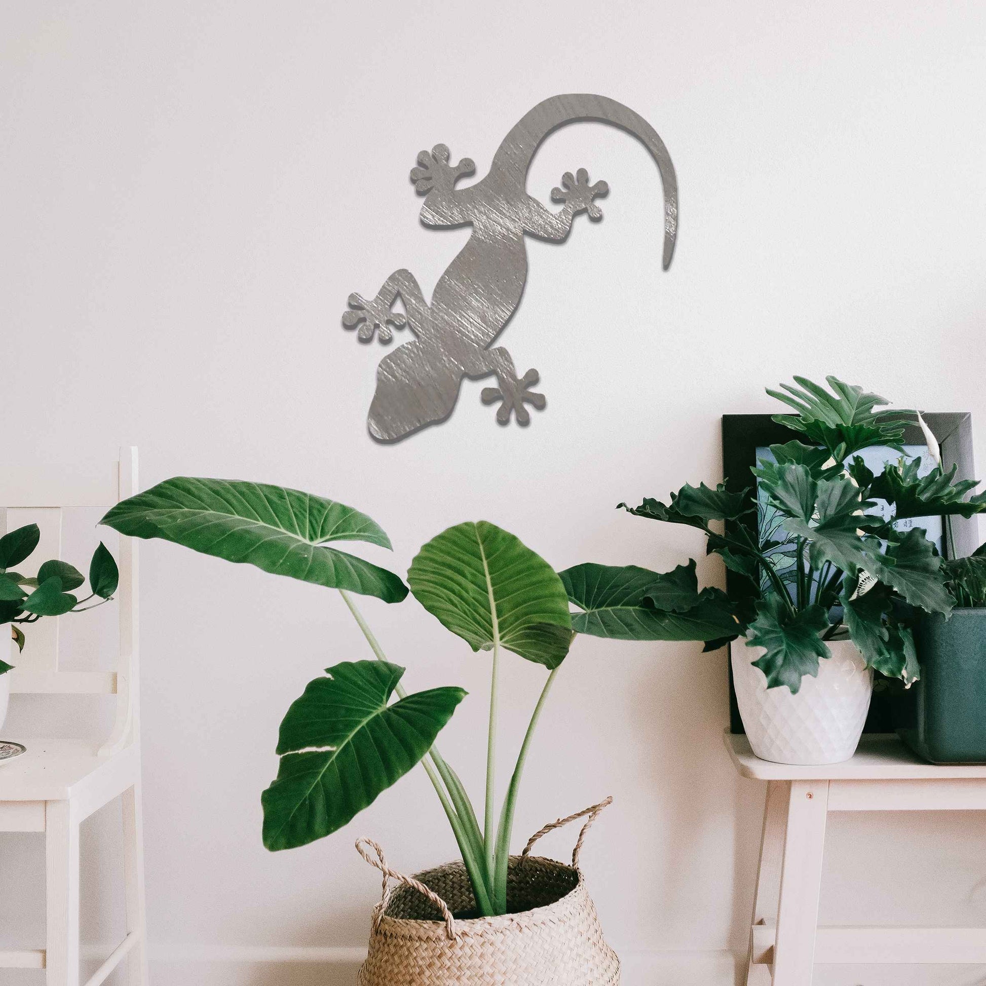 Metal wall decoration featuring a simple gecko silhouette design, adding a minimalist and modern touch to indoor spaces, displayed on a neutral wall within a contemporary decor setting.