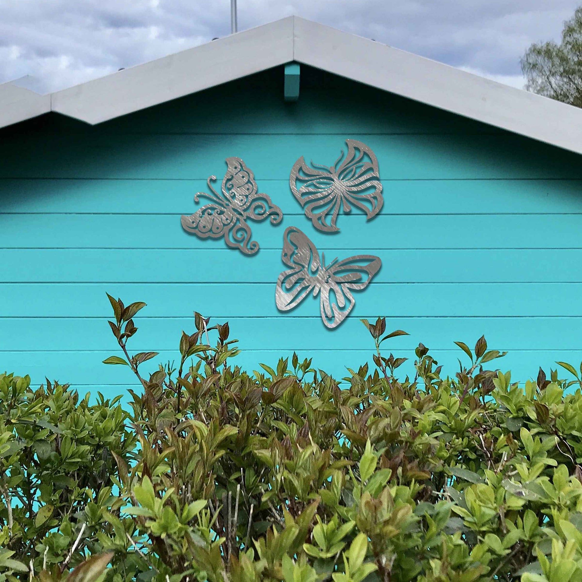 Set of metal garden decorations featuring three distinct butterfly designs with intricate patterns, adding a playful and nature-inspired charm to outdoor walls, fences, or garden spaces