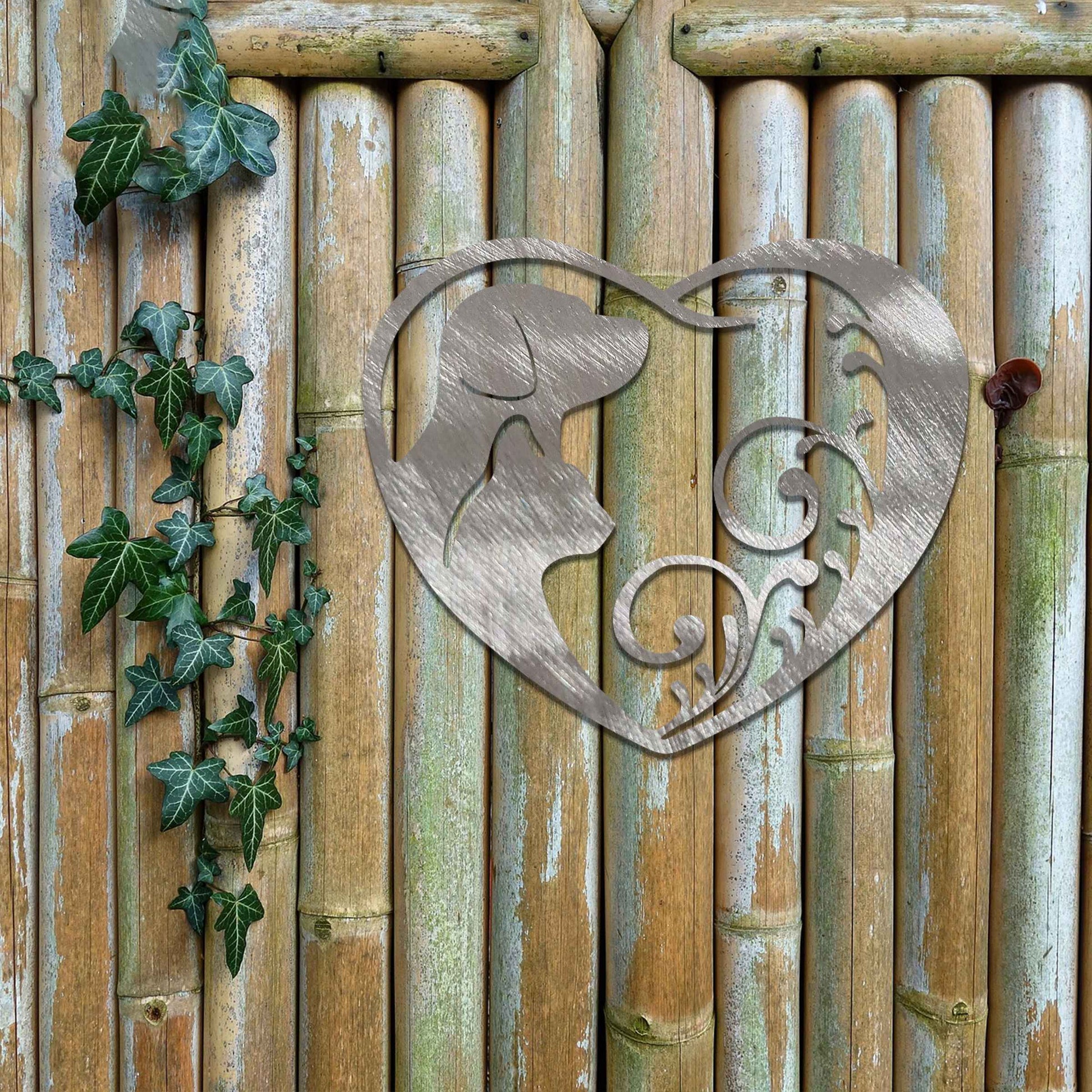 Metal garden decoration featuring a heart-shaped design with silhouettes of a dog and cat intertwined with elegant scrollwork, symbolising love for pets and adding a decorative charm to outdoor walls or garden spaces.