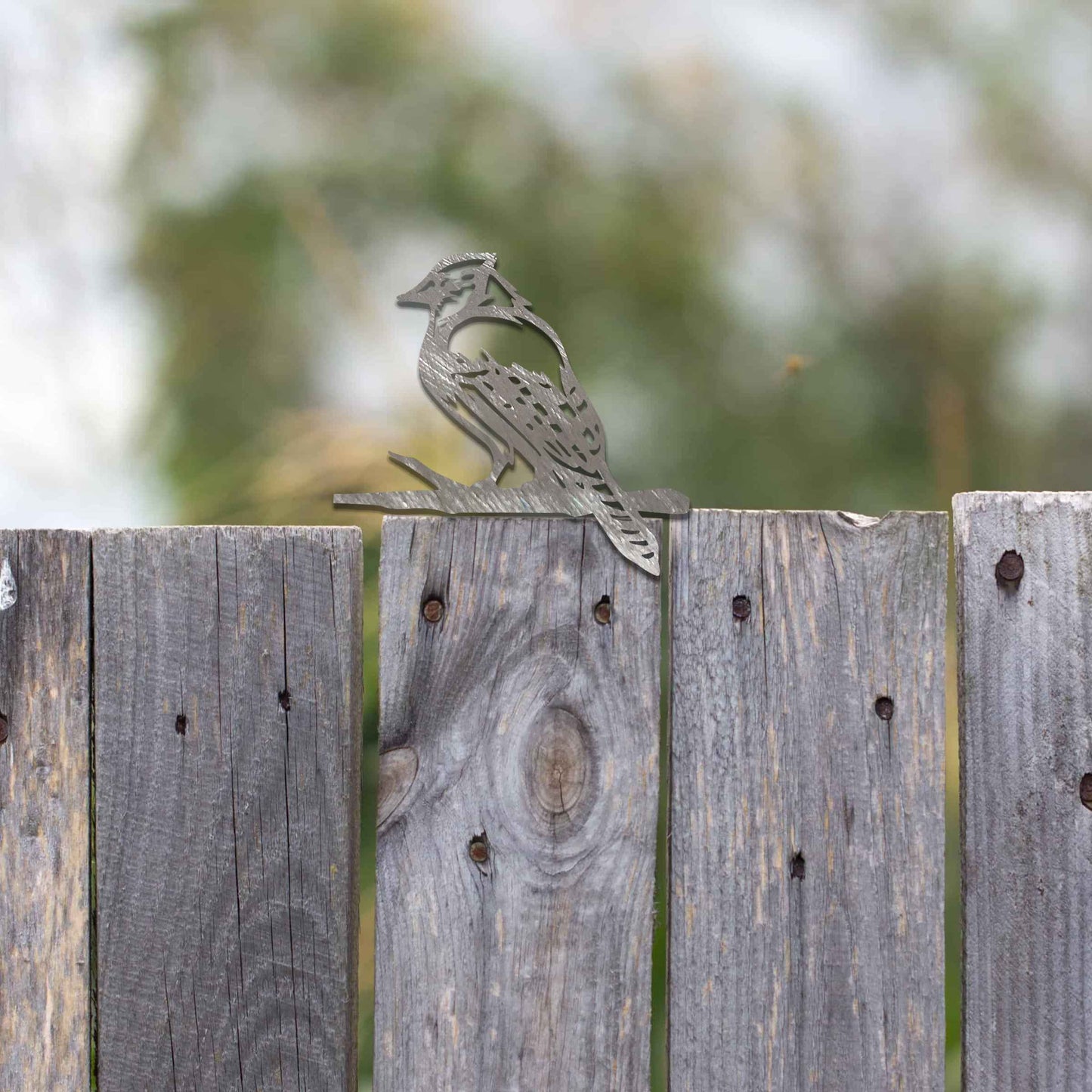 Metal garden decoration featuring a woodpecker silhouette with intricate cutout details and a rustic finish, designed to perch on wooden beams or posts, adding a natural and artistic touch to outdoor spaces.
