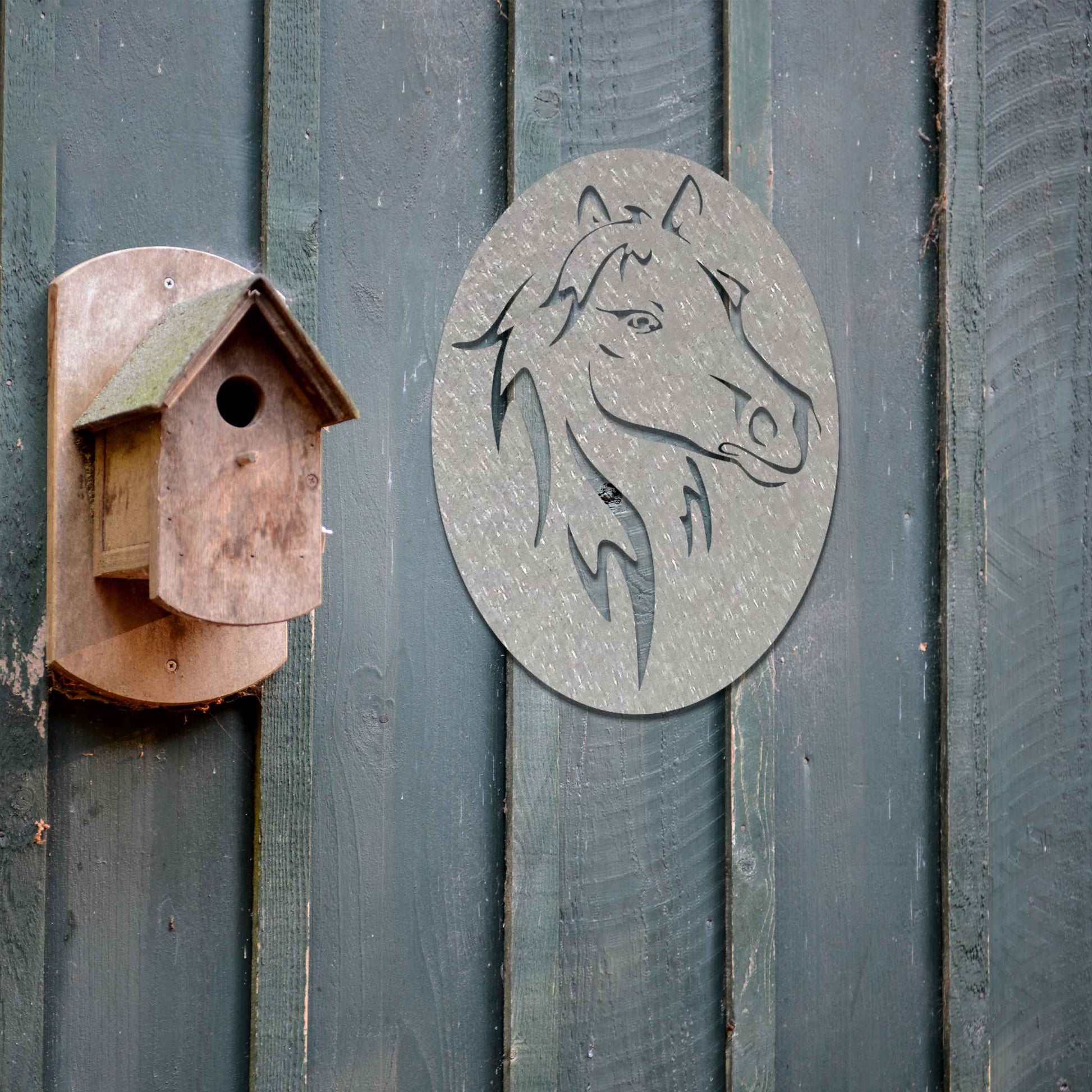 Metal wall art featuring a horse's head within an oval frame, highlighting intricate details of the mane and facial features. The design is bold and dynamic, capturing the strength and elegance of the horse in a stylized and striking manner.